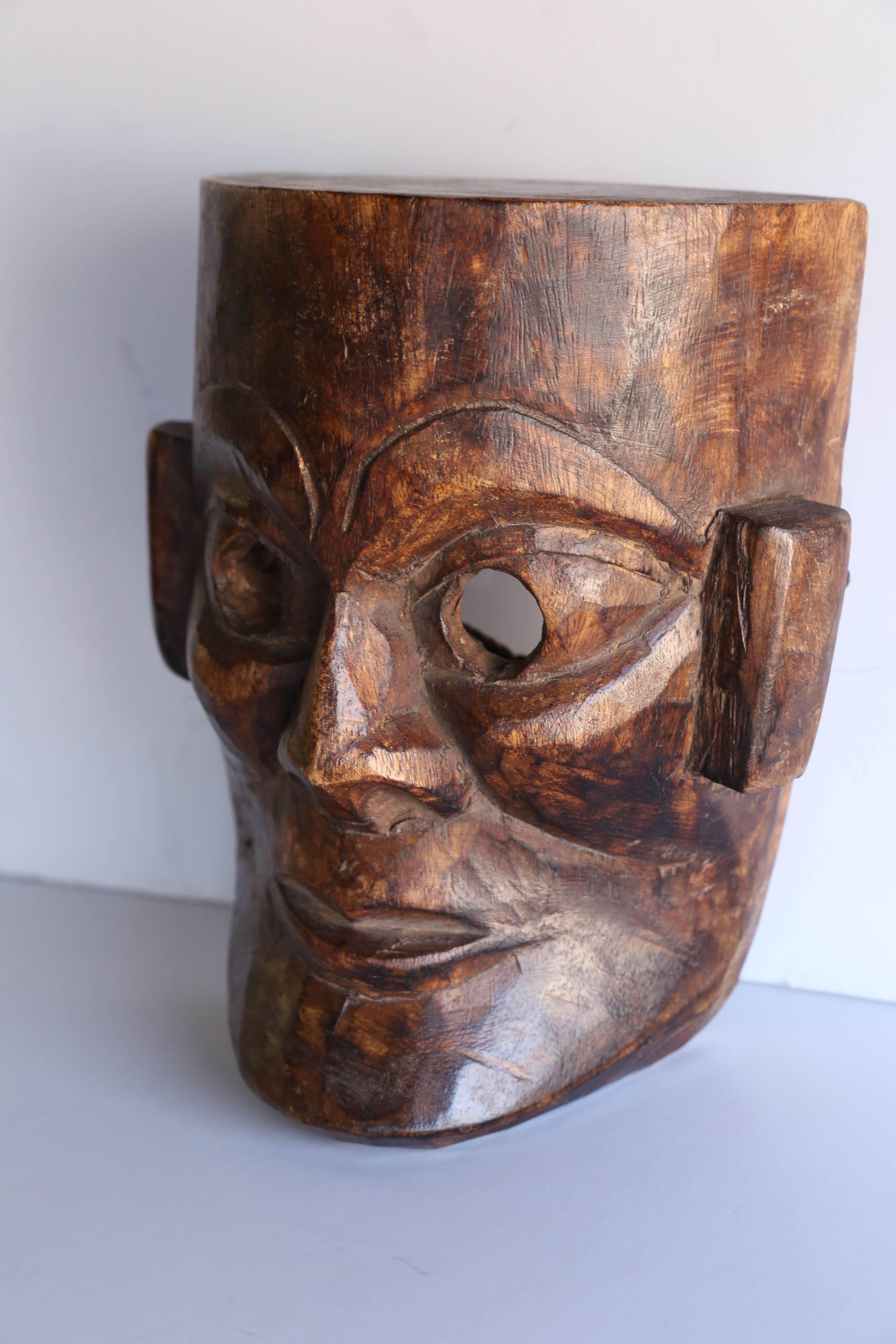 This mask was hand-carved from one piece of solid wood block. It comes from east Nepal. During festival times people wear this kind of masks and march in procession.