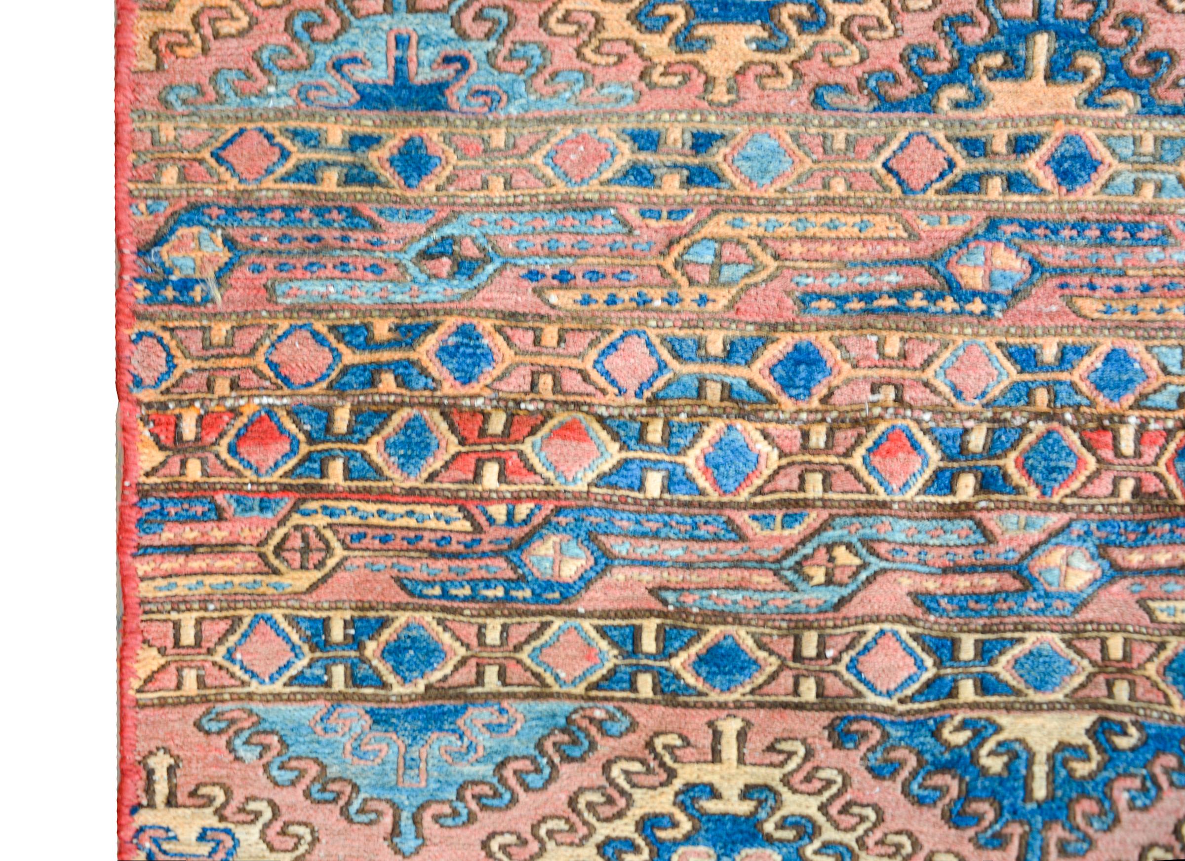 An interesting early 20th century Persian Soumak rug with bold stripes woven with stylized floral patterns, and flanked with white flat woven ends.