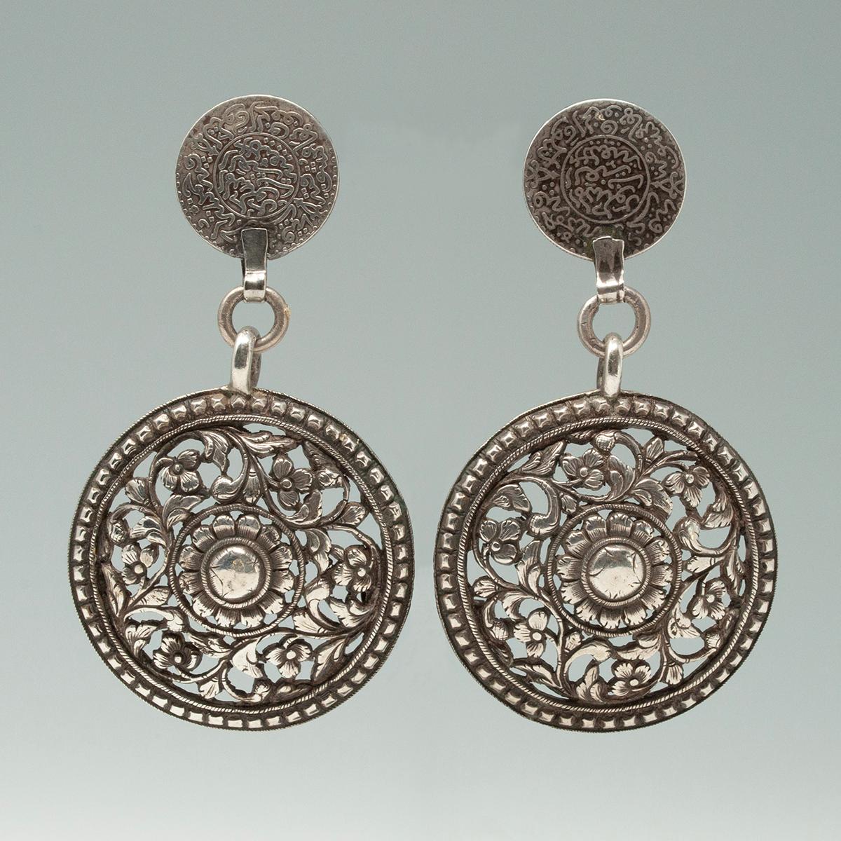 Early 20th Century South Indian Silver Charm Earrings by Jewels of Santa Fe/Marrakesh

A dramatic pair of earrings made by Jewels with large filigree silver charms from South India anchored by 19th century North African coins.

They are 4 inches