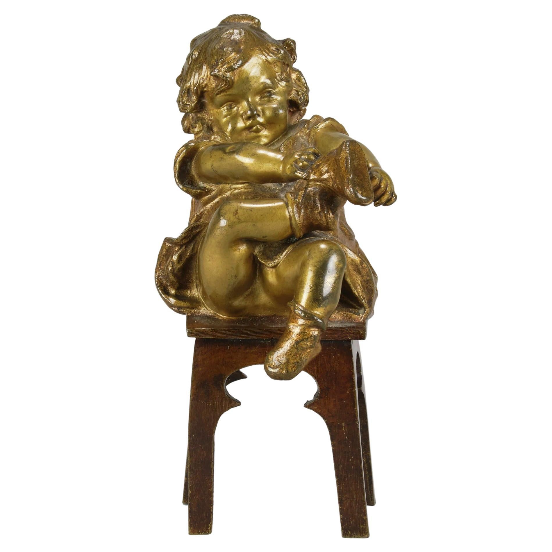 Bronzo spagnolo dei primi del Novecento intitolato "Ragazza che si mette le scarpe" di J Clara