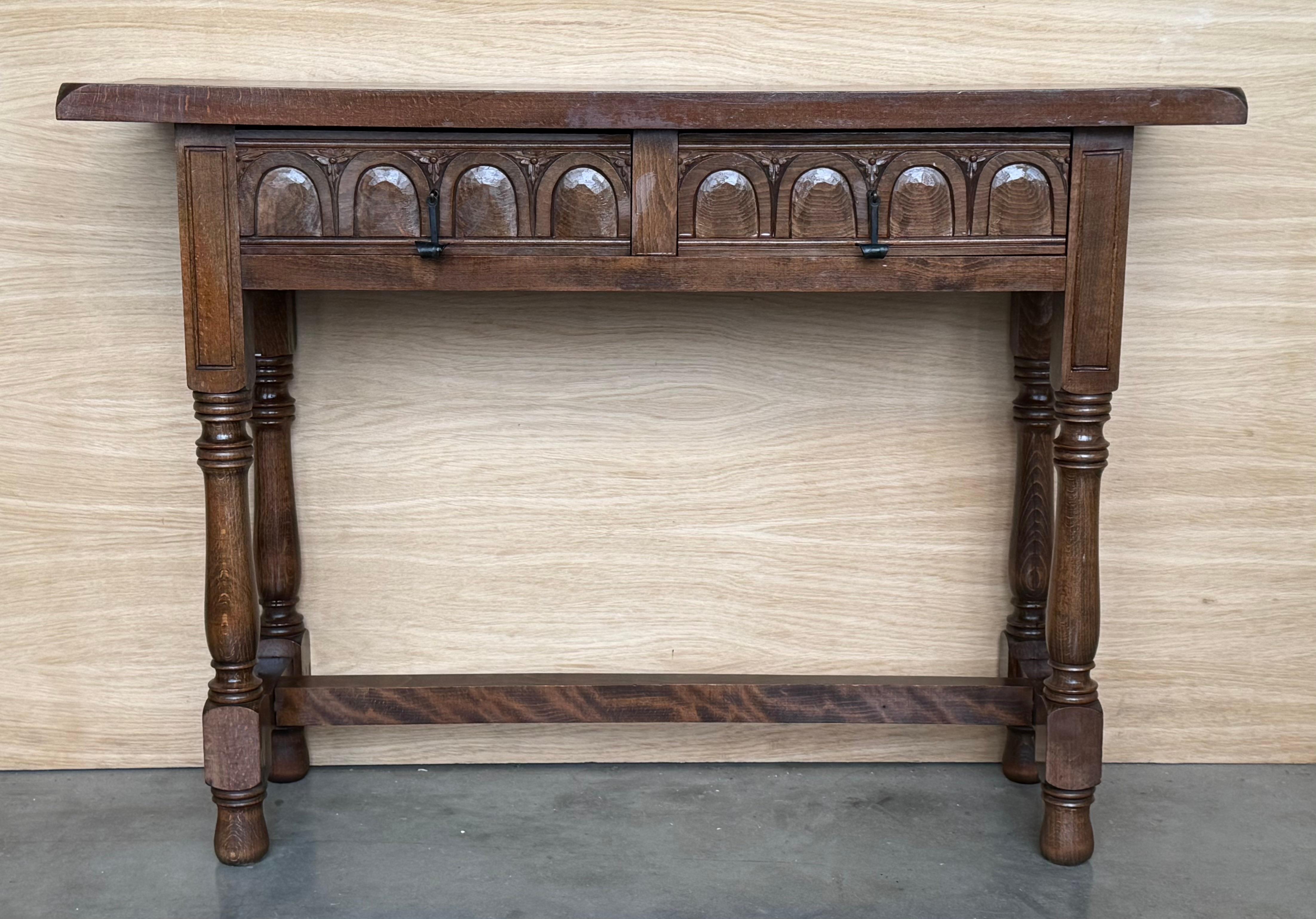 Early 20th century carved Spanish console with fluted legs and a two drawers with hardware

This table with character is of rare narrow depth. It is characteristic of Spanish Baroque furniture with a thick one-piece top, a simple and bold