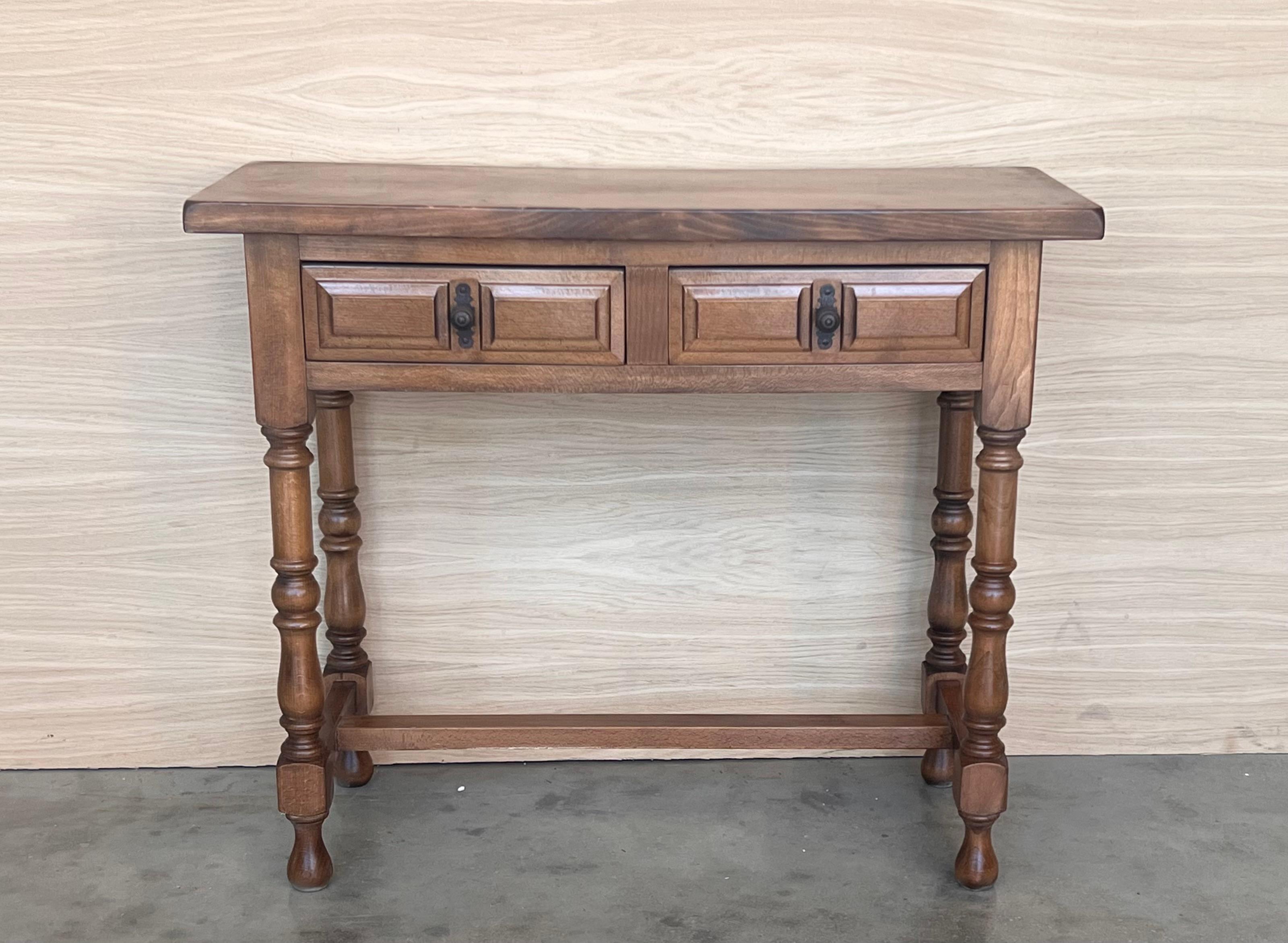 Early 20th century carved Spanish console with two drawers.
This table with character is of rare narrow depth. It is characteristic of Spanish Baroque furniture with a thick one-piece top, a simple and bold carved drawers and turnings legs. It has a
