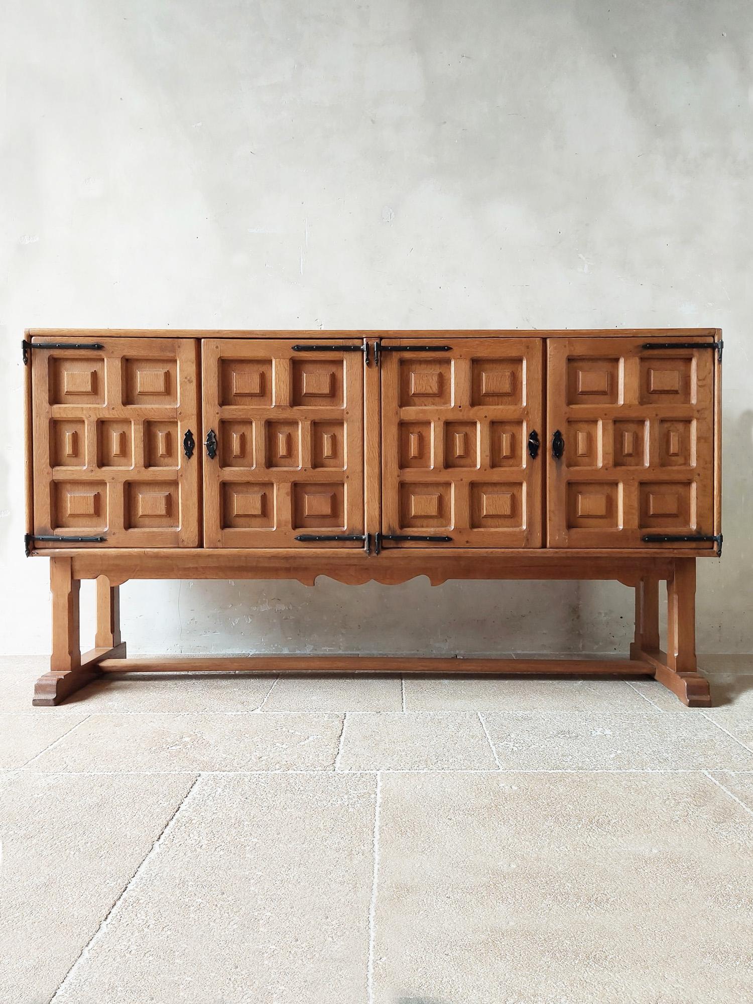 Spanish carved wooden credenza with 4 doors with carved geometrical shapes, raised on a base. Brutalist style. Early 20th century.

Measures: H 102 x W 200 x D 50 cm.