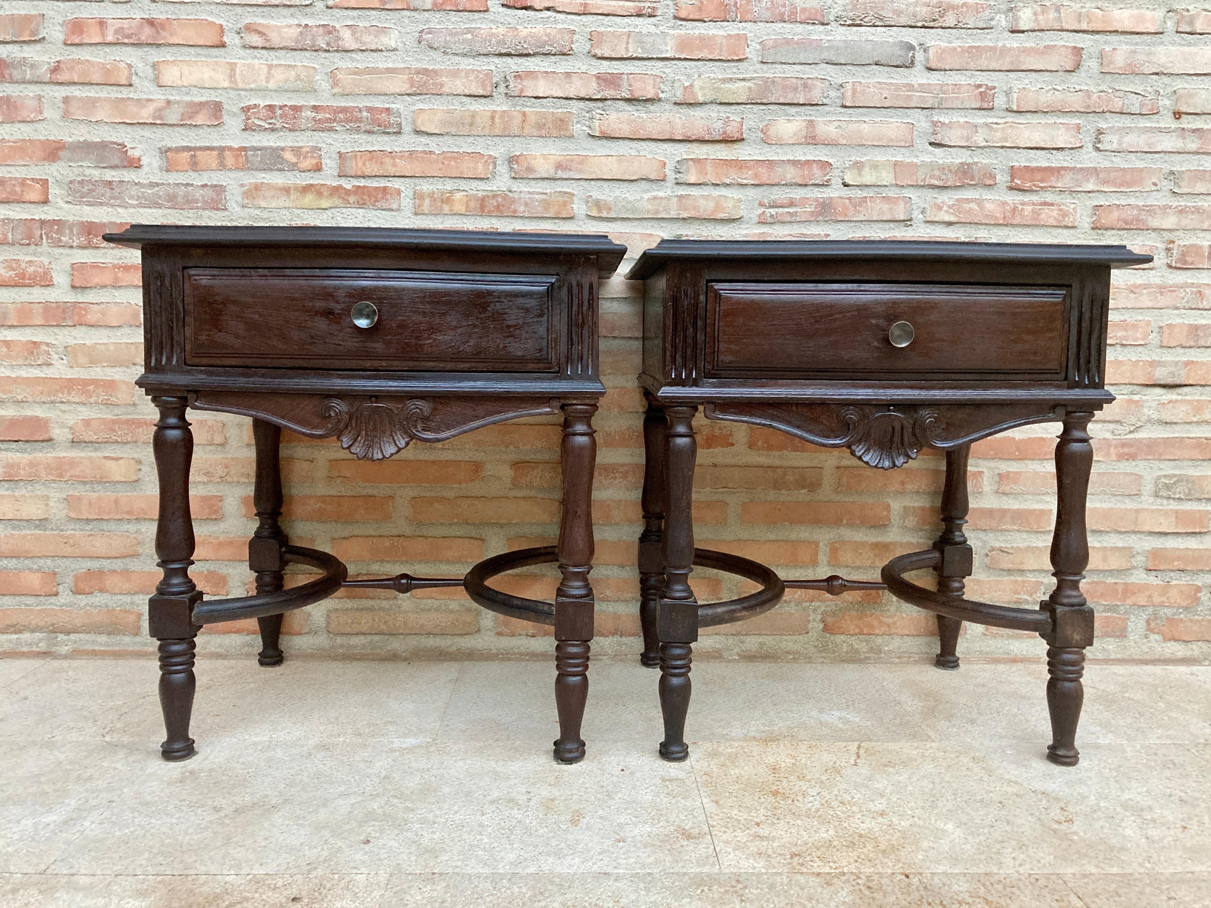 Pair of early 20th century Spanish chestnut nightstands or bedside tables with one drawer and metal hardware.
Beautiful very decorative bedside tables with a nice central joint that makes them different. 
They have a drawer lined inside with a