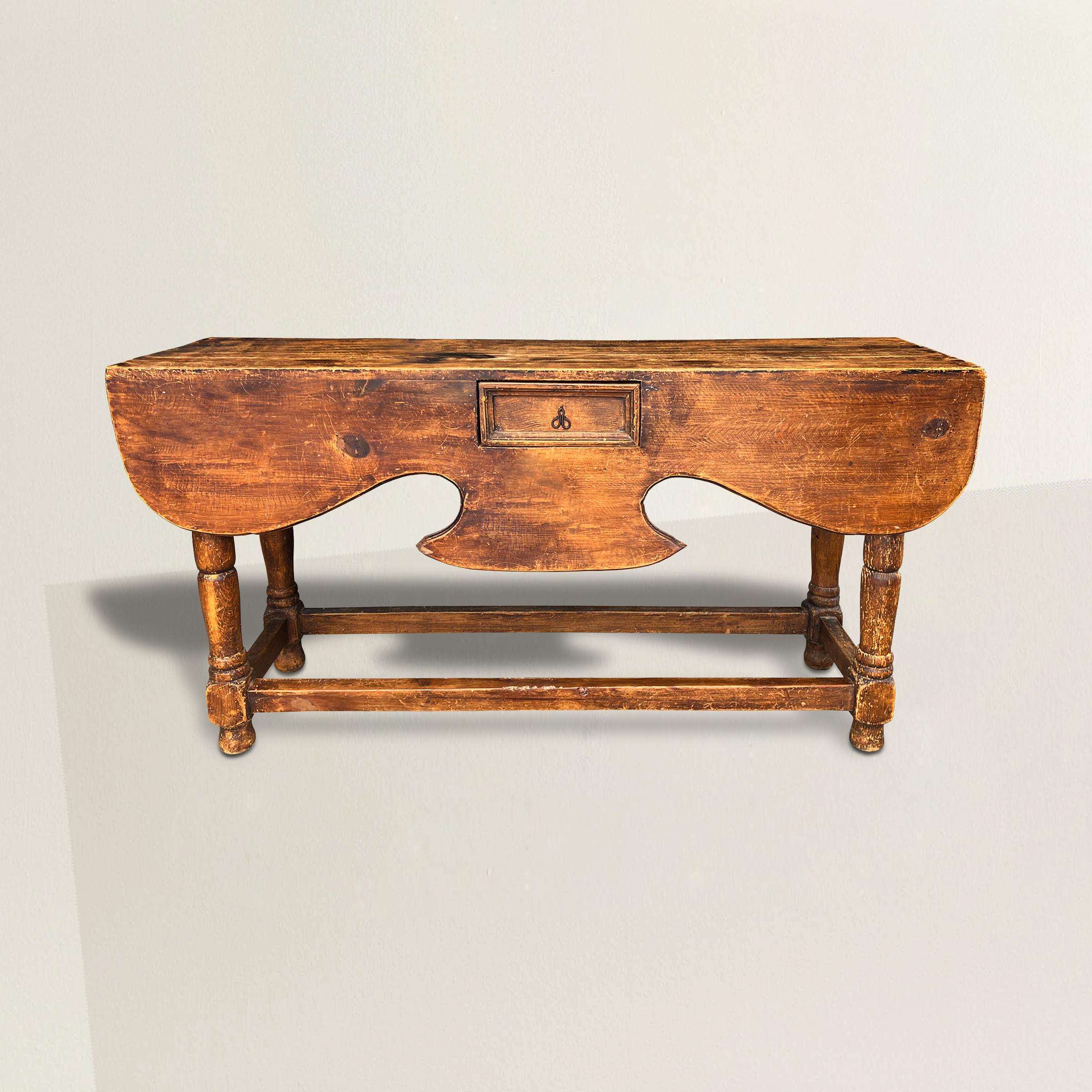 A bold and playful early 20th century Mexican Spanish colonial console table with a wide sculptural apron with one drawer, and supported by turned legs with stretchers. The perfect console in your entry way or behind a sofa, or used as a sideboard