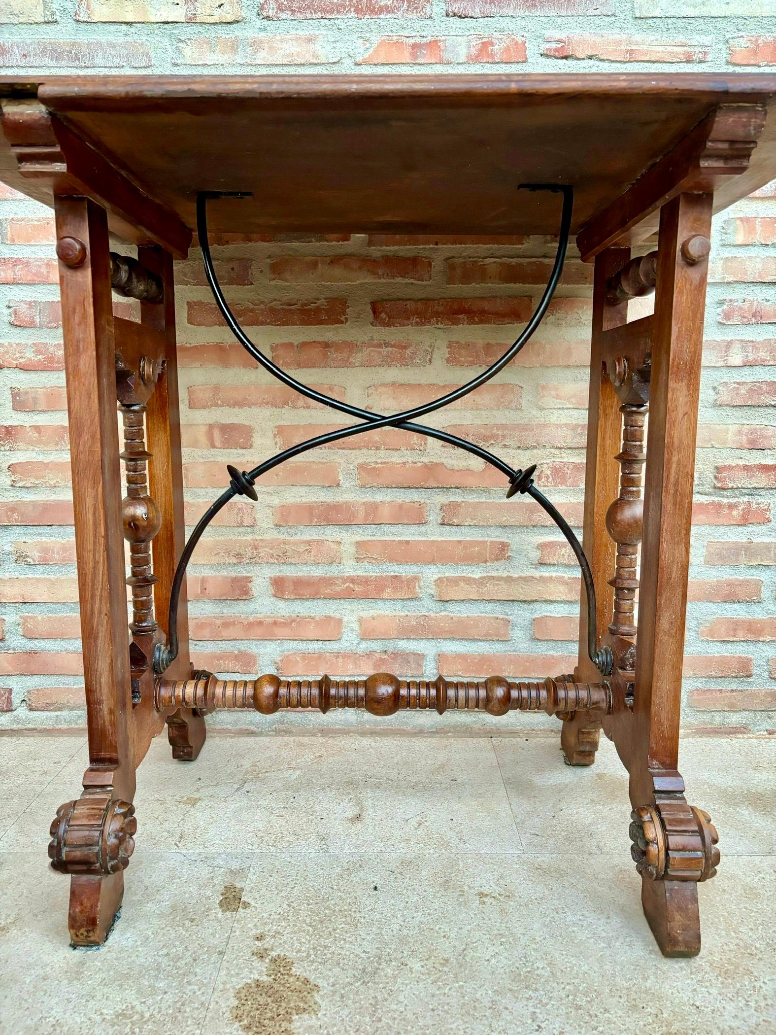 Table console espagnole du début du 20e siècle. Console espagnole du début du XXe siècle à quatre pieds piédestaux reliés par une barre sculptée et des attaches en fer.