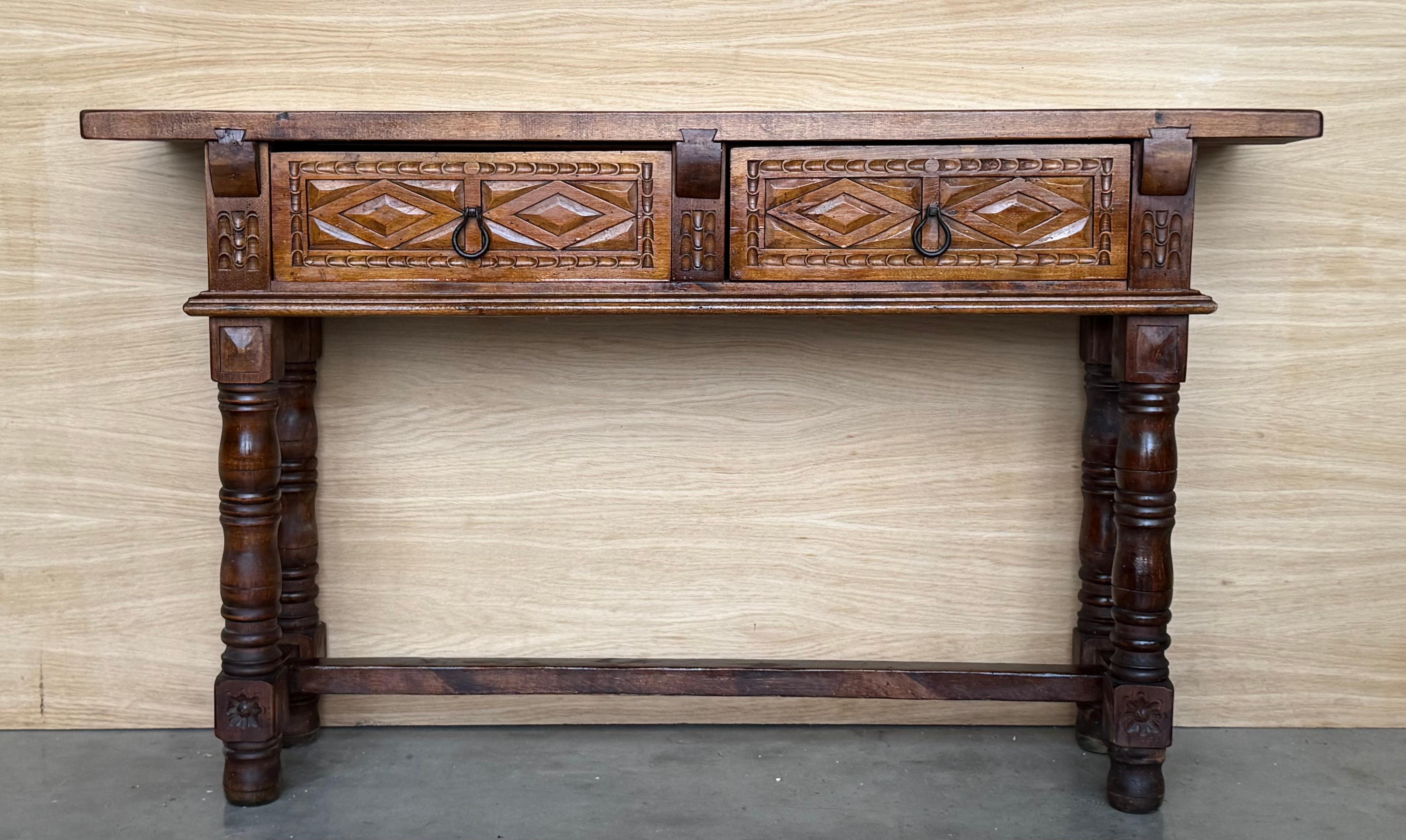 
Spanish Baroque furniture with a single piece top. It has a rich lustrous patina. The thick single plank walnut top with fine figuring. The front fitted with two drawers decorated with chip carving and with iron knobs. Standing on bold ring turned