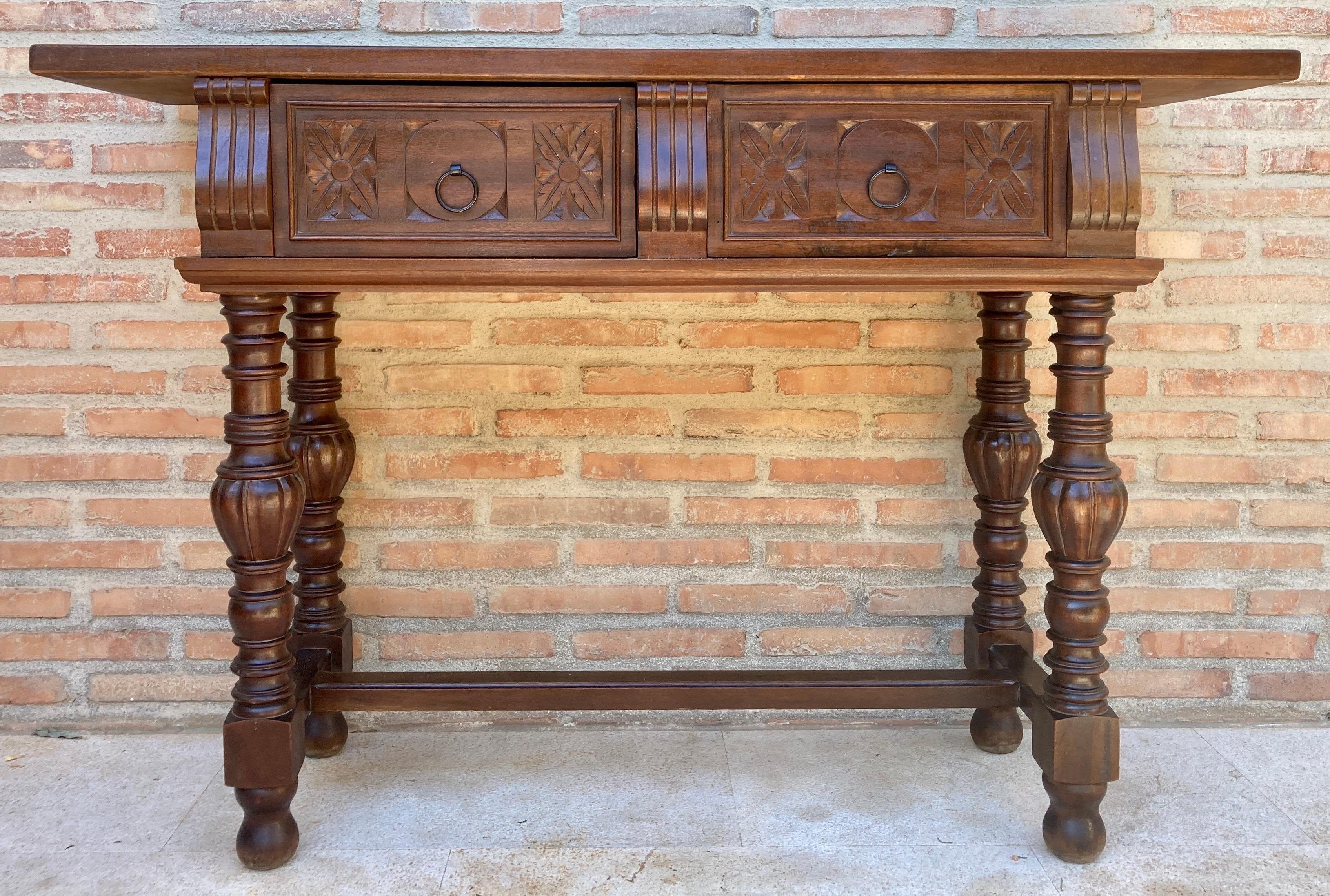 This console table is characteristic of Spanish baroque furniture with a thick one-piece top, simple and bold chip-carved embellishment and bold turnings. It has a rich patina.