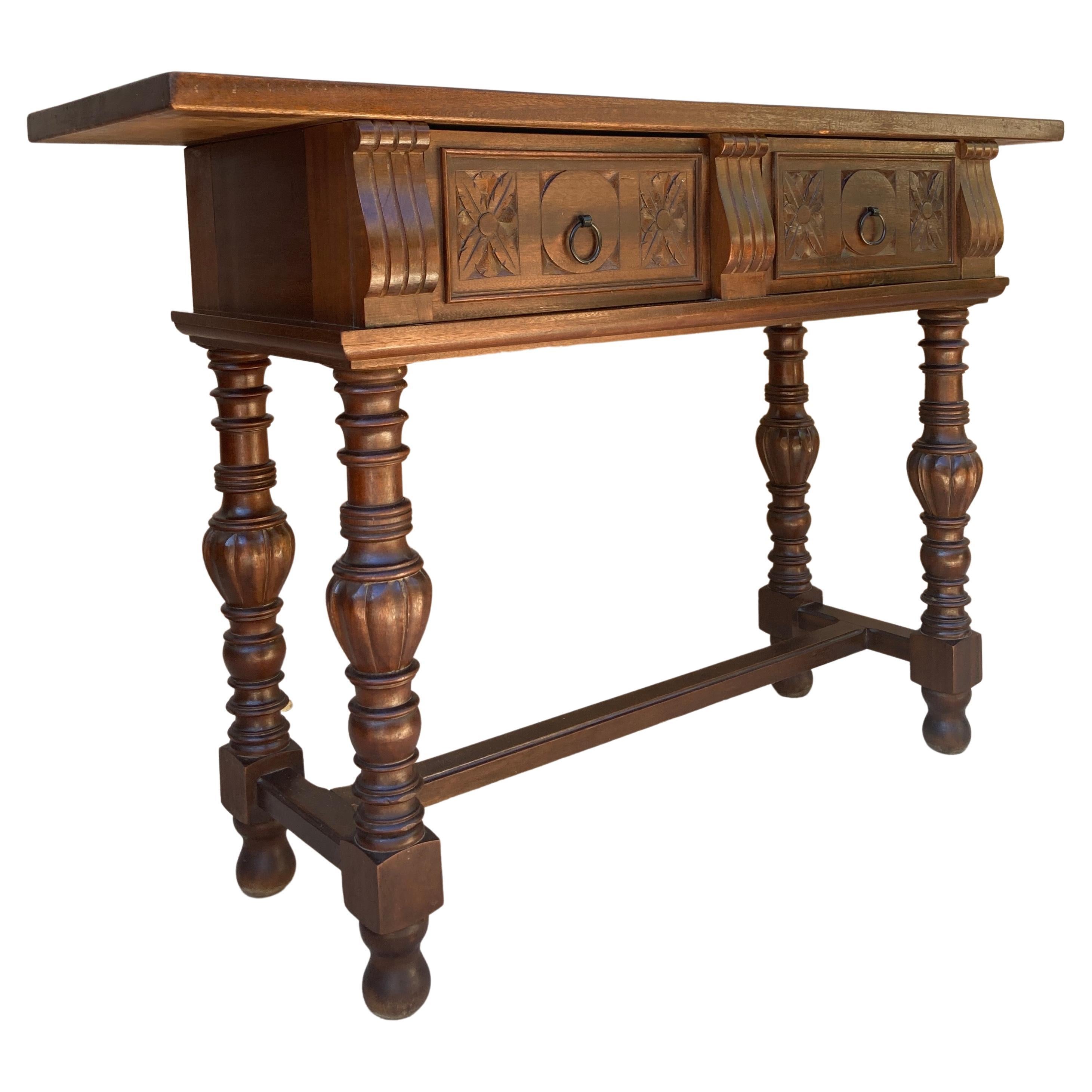 Table console espagnole du début du 20e siècle avec deux tiroirs sculptés et pieds tournés