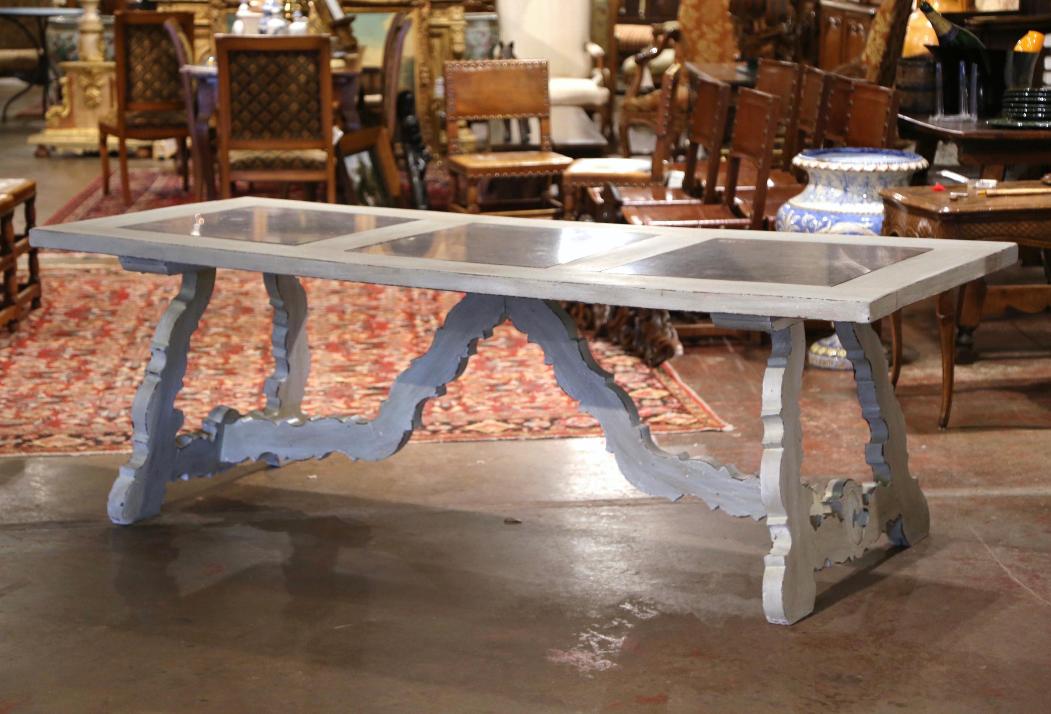 Décorez une salle à manger ou une salle de petit-déjeuner avec cette élégante table peinte ancienne. Sculptée en Espagne vers 1930, cette grande table à tréteaux repose sur deux pieds sculptés complexes, reliés par un épais châssis en croix à