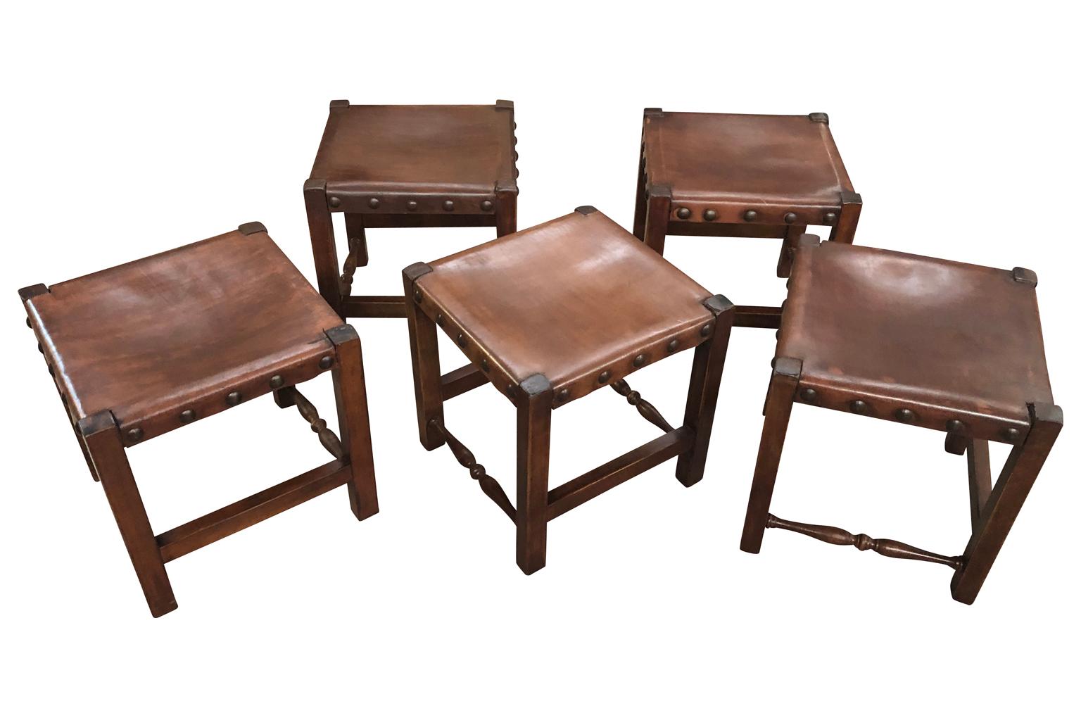 A set of 5 early 20th century Spanish stools handsomely constructed from beech and leather. Great accent pieces.
