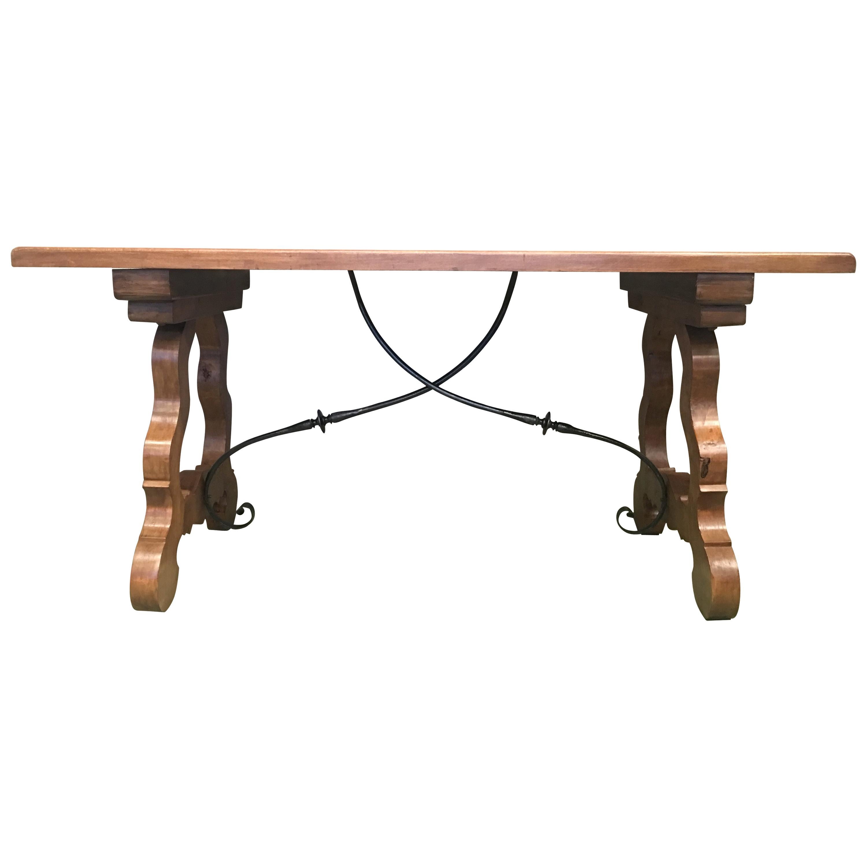 20th century Spanish walnut desk or farm table with iron stretchers
Elegant antique walnut farm table from Spain; crafted circa 1920, the trestle table features a rectangular top over two carved and shaped lyre-form legs joined by forged iron