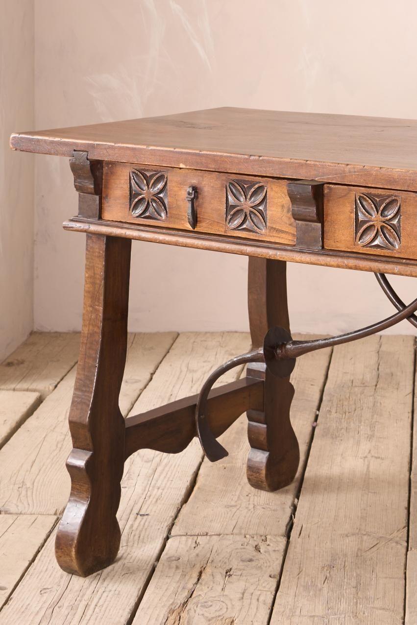 This is a great designed early 20th century Spanish writing table. Made from solid walnut with a single slab top with an incredible patina. The carved drawer fronts give this a great decorative appeal as well as practicality as a writing or vanity