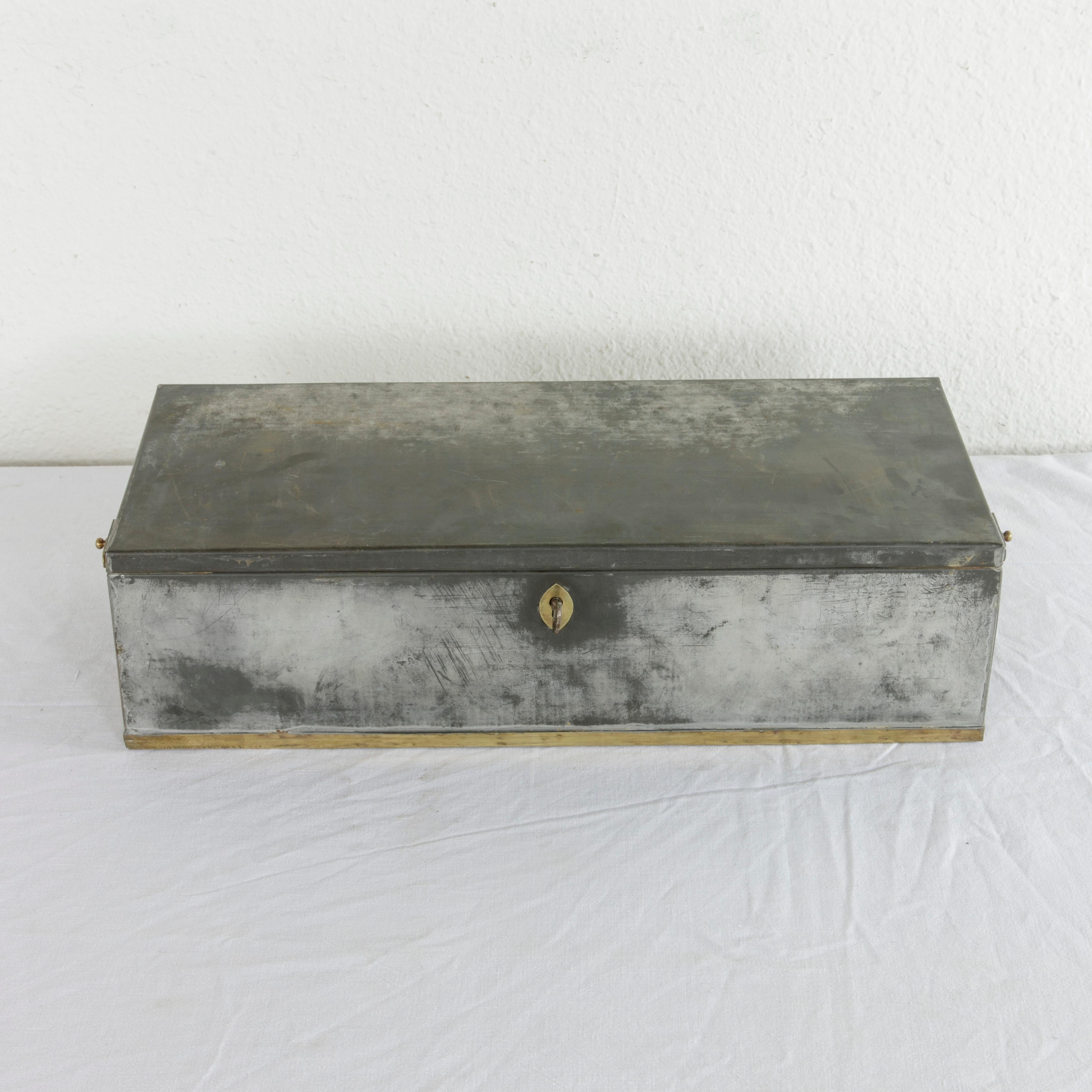This early 20th century steel lock box or safety deposit box from the Banco Central of Barcelona in Spain features its original brass handles, trim, and key entry. The hand-painted number 664 is on one side, and the box includes its two original
