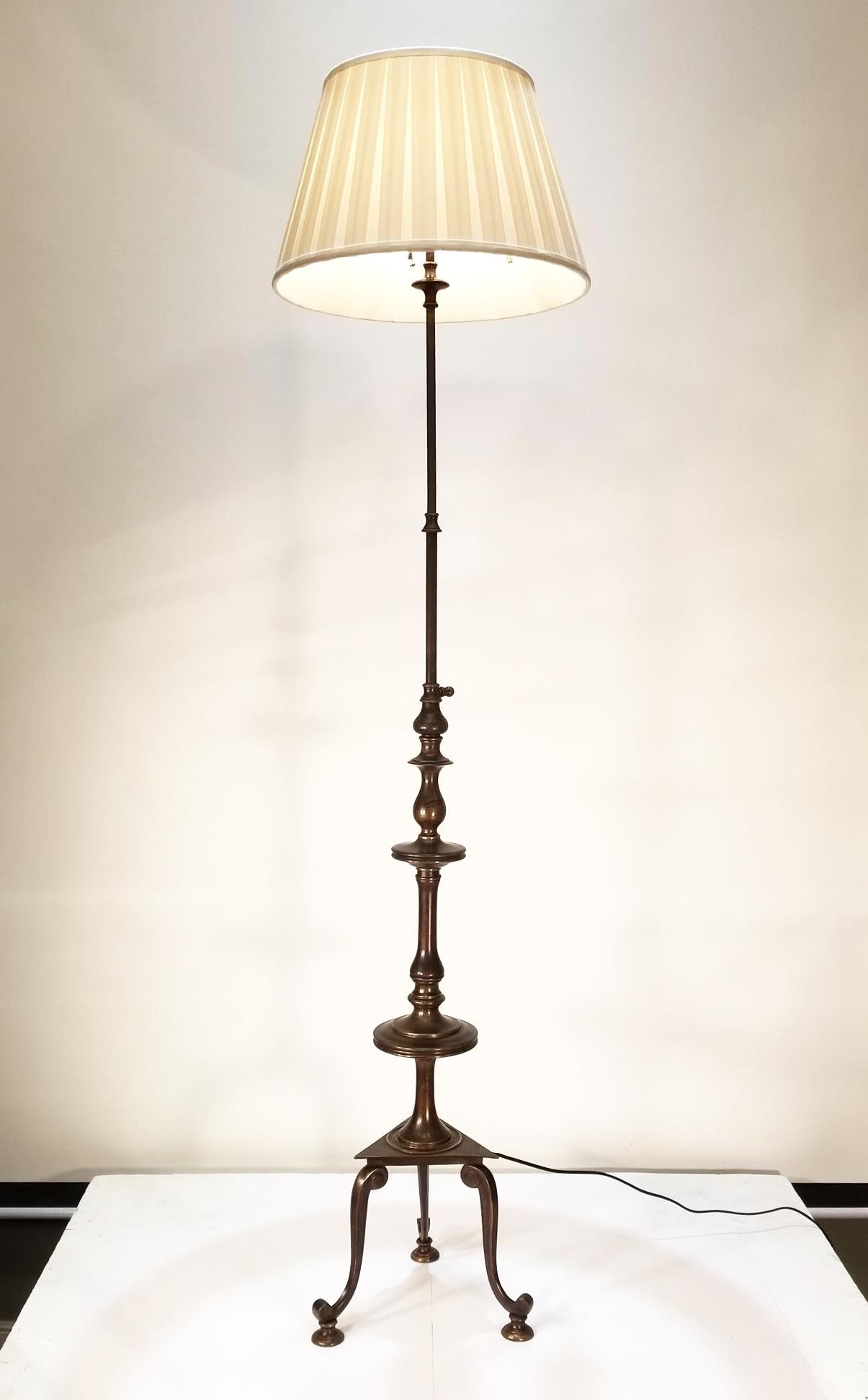 A beautiful patinated bronze antique floor lamp with a classical turned and cast stem that can be adjusted in height from 58 inches to 68 inches or anywhere in between. This tripartite base lamp retains its original three light pull chain cluster