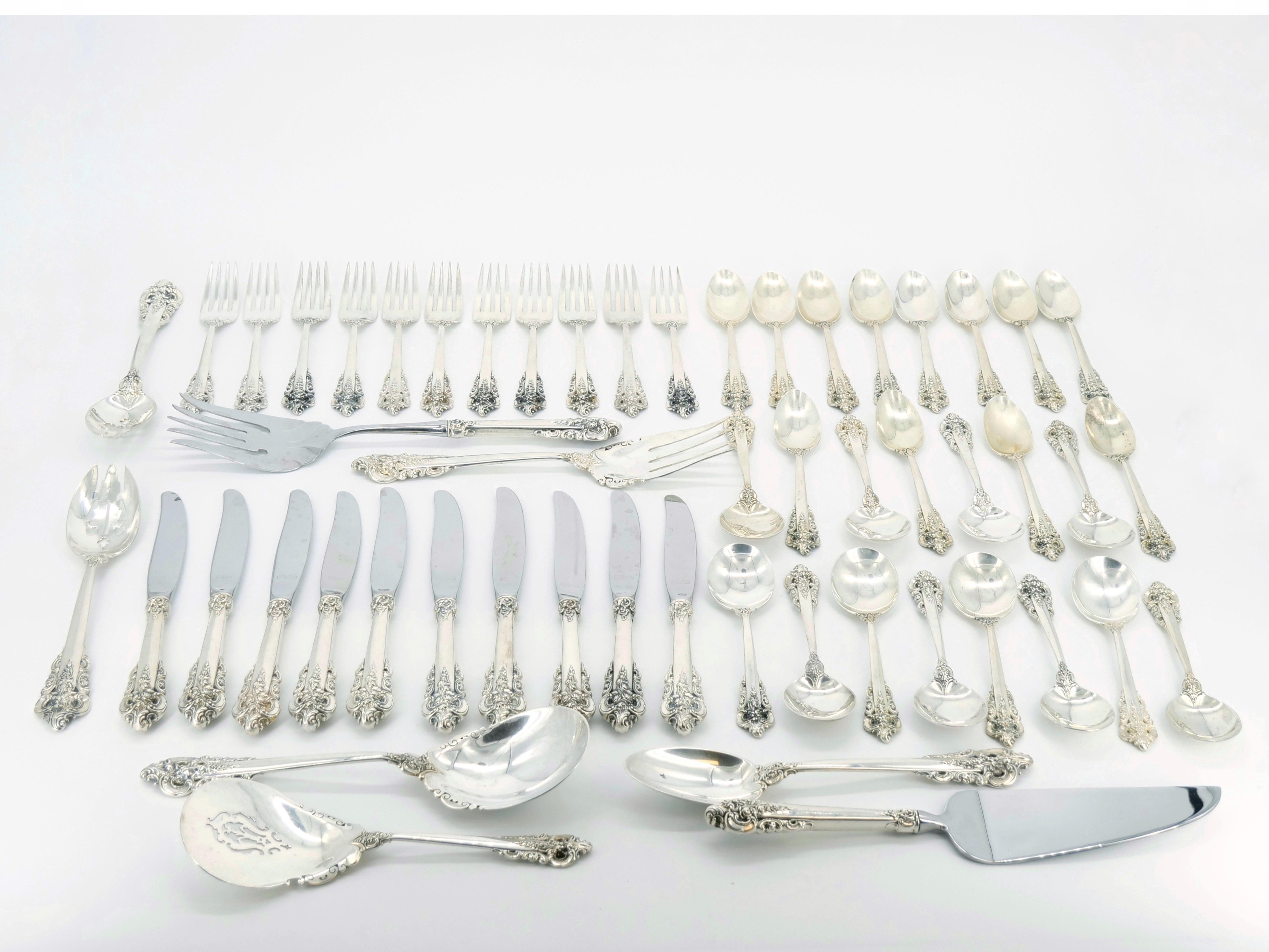 Elevate your dining experience with this exceptional North American Sterling Silver Flatware Service from the early 20th century, featuring the timeless elegance of the renowned Wallace Grand Baroque pattern. Meticulously maintained and in great
