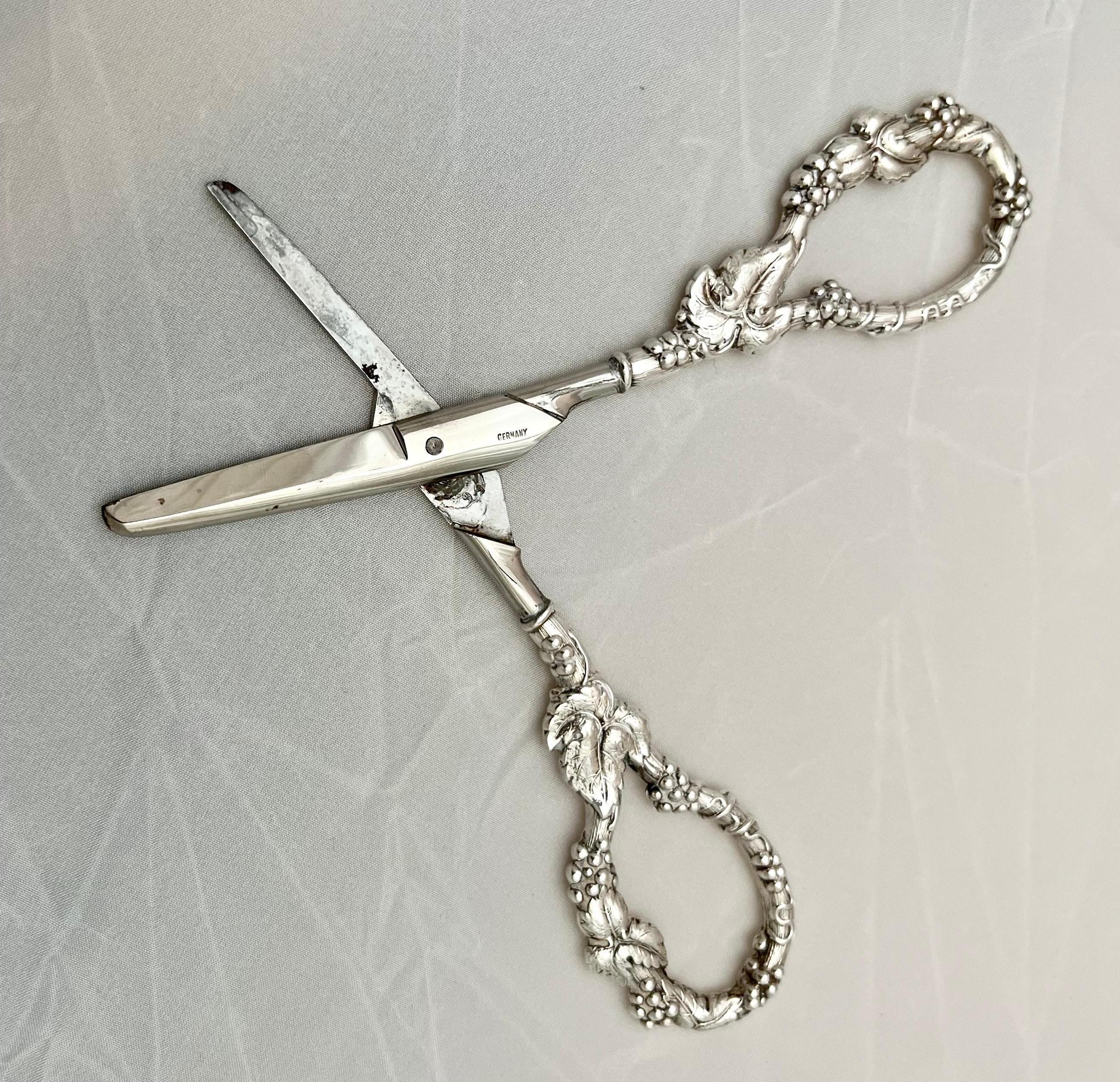 Pair of sterling silver repousse scissors for cutting grape vines. The scissors is beautifully decorated with grapes, leaves & vines. The actual cutting portion is constructed of stainless steel. Hallmarked as depicted in photos.