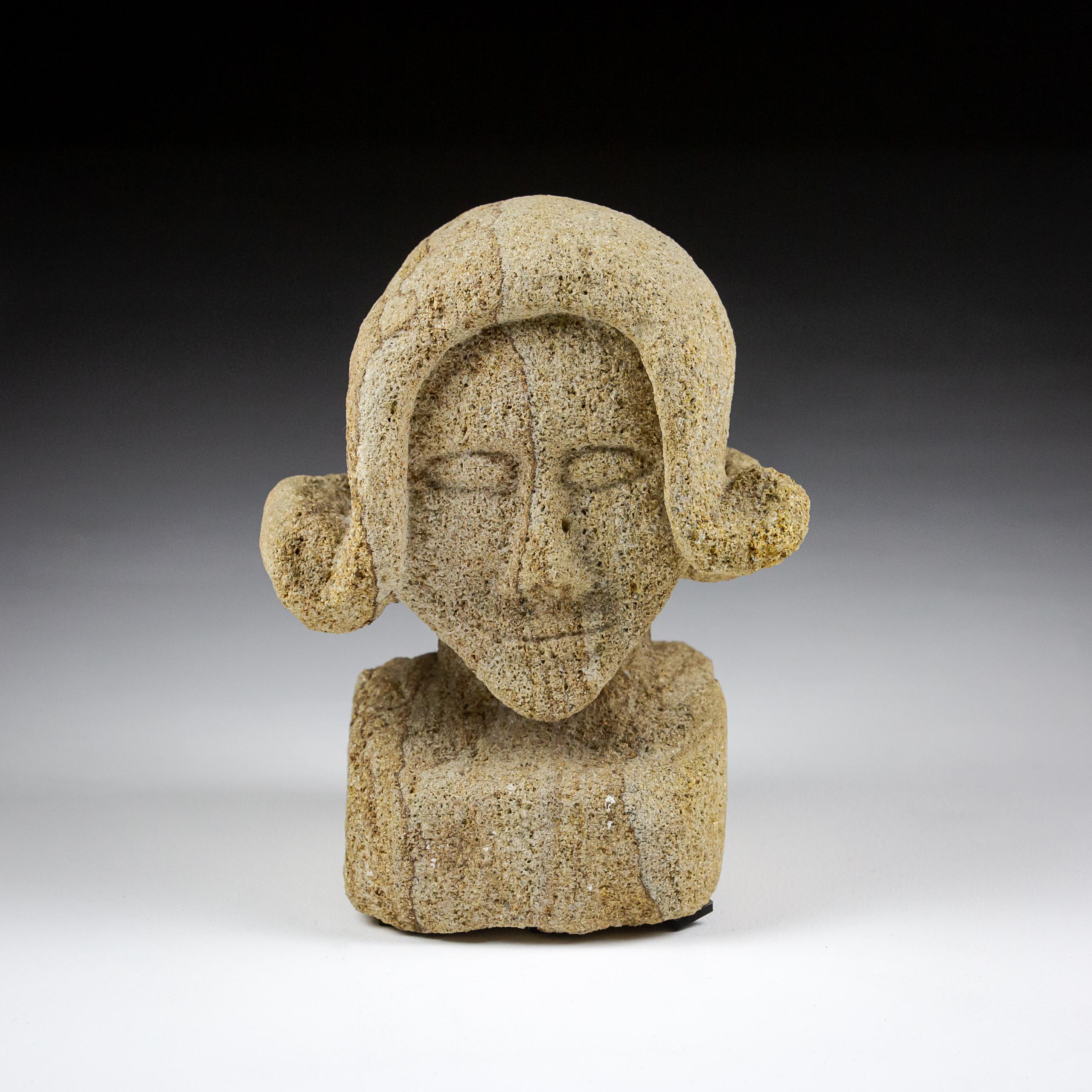 Early 20th Century Primitive carved stone bust. impressive stylised hair. Interesting strata patterns running through the stone. Signed indistinctly. France Circa 1900.