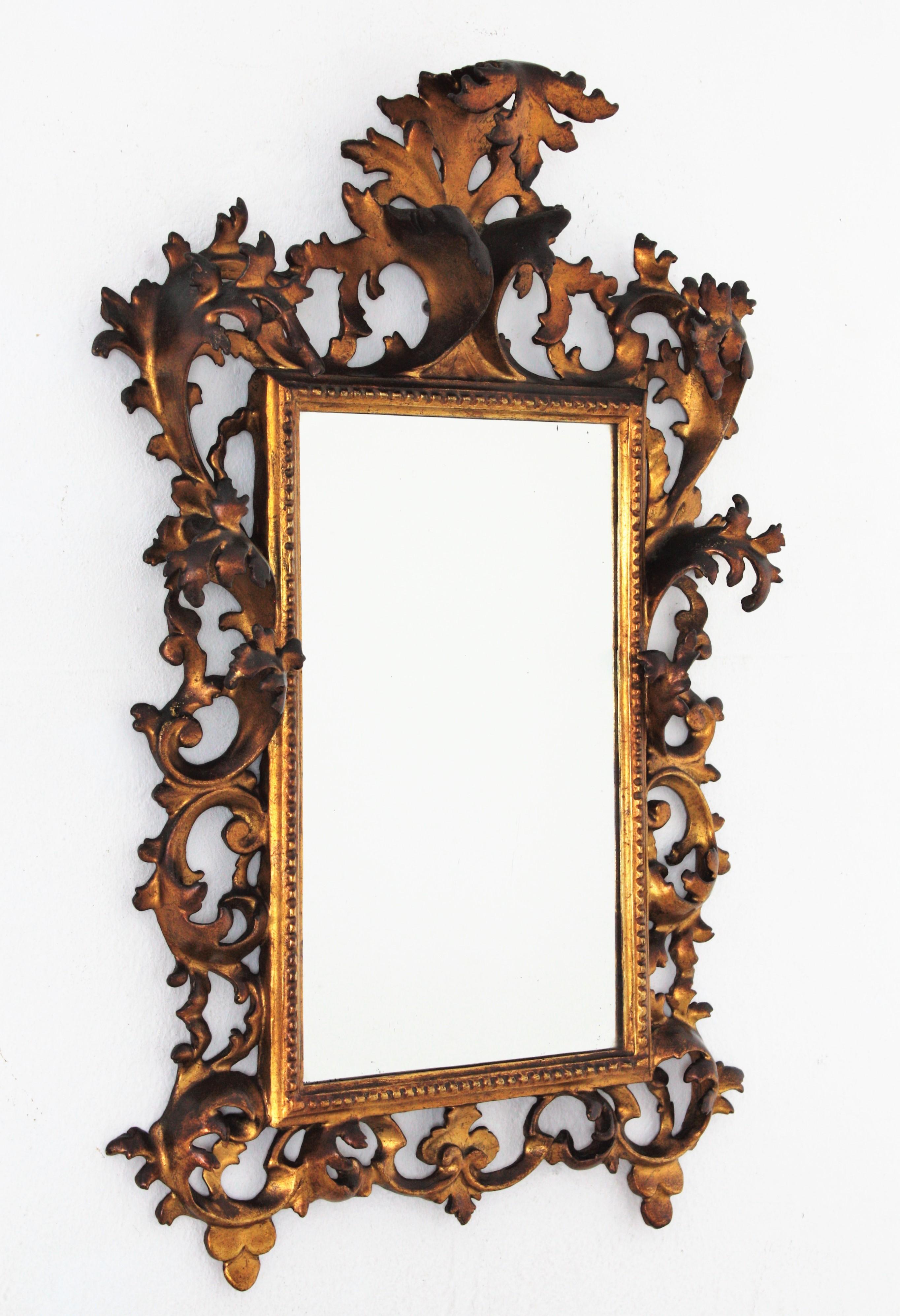 Spanish Early 20th Century Carved Giltwood Rococo Mirror with Crest For Sale