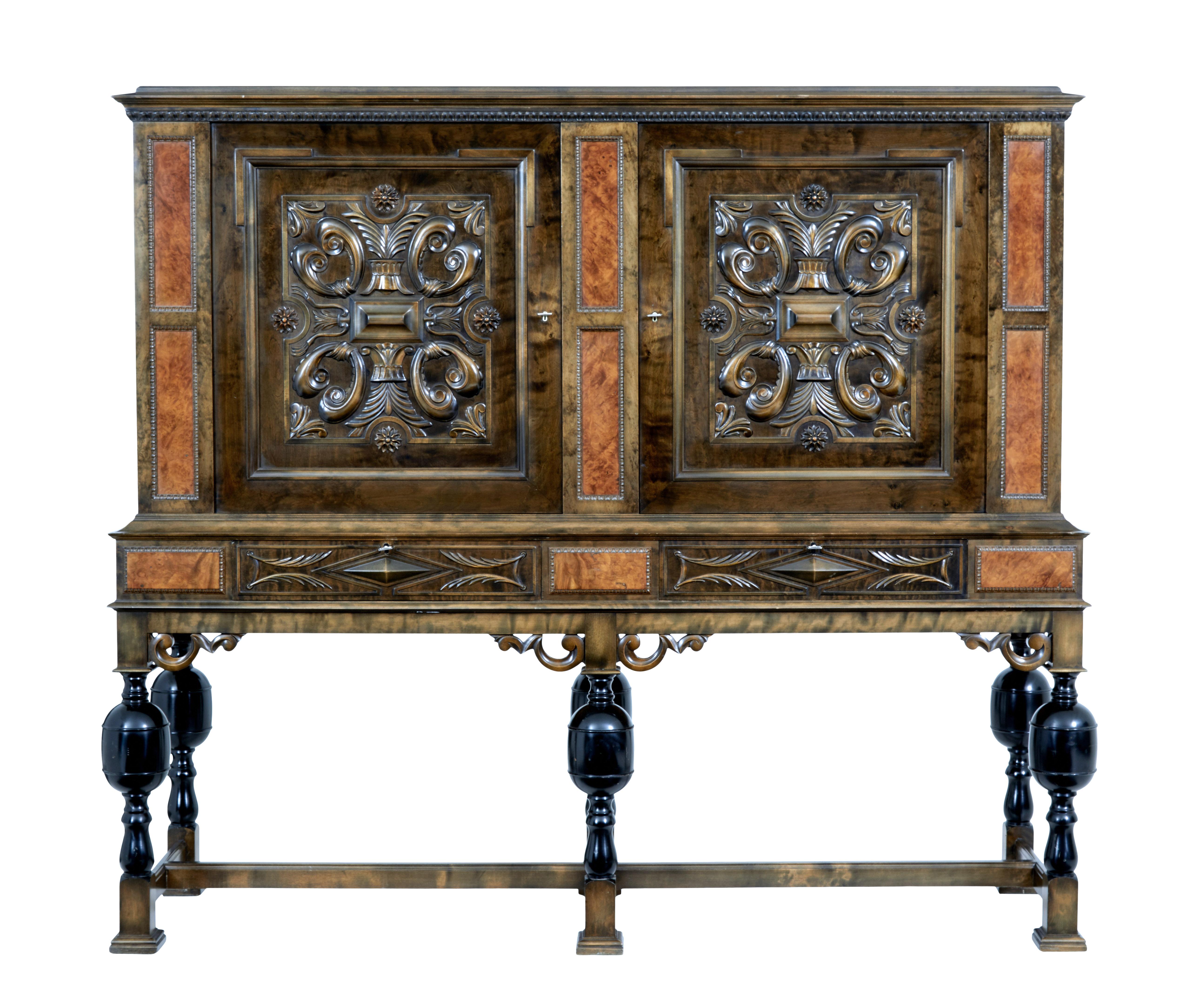 Early 20th century Swedish baroque revival birch cabinet circa 1920.

Here we present a striking dark stained birch cabinet from Sweden. Cornice top with moulded edge underneath. Double door cabinet with applied decorative mouldings of swags and