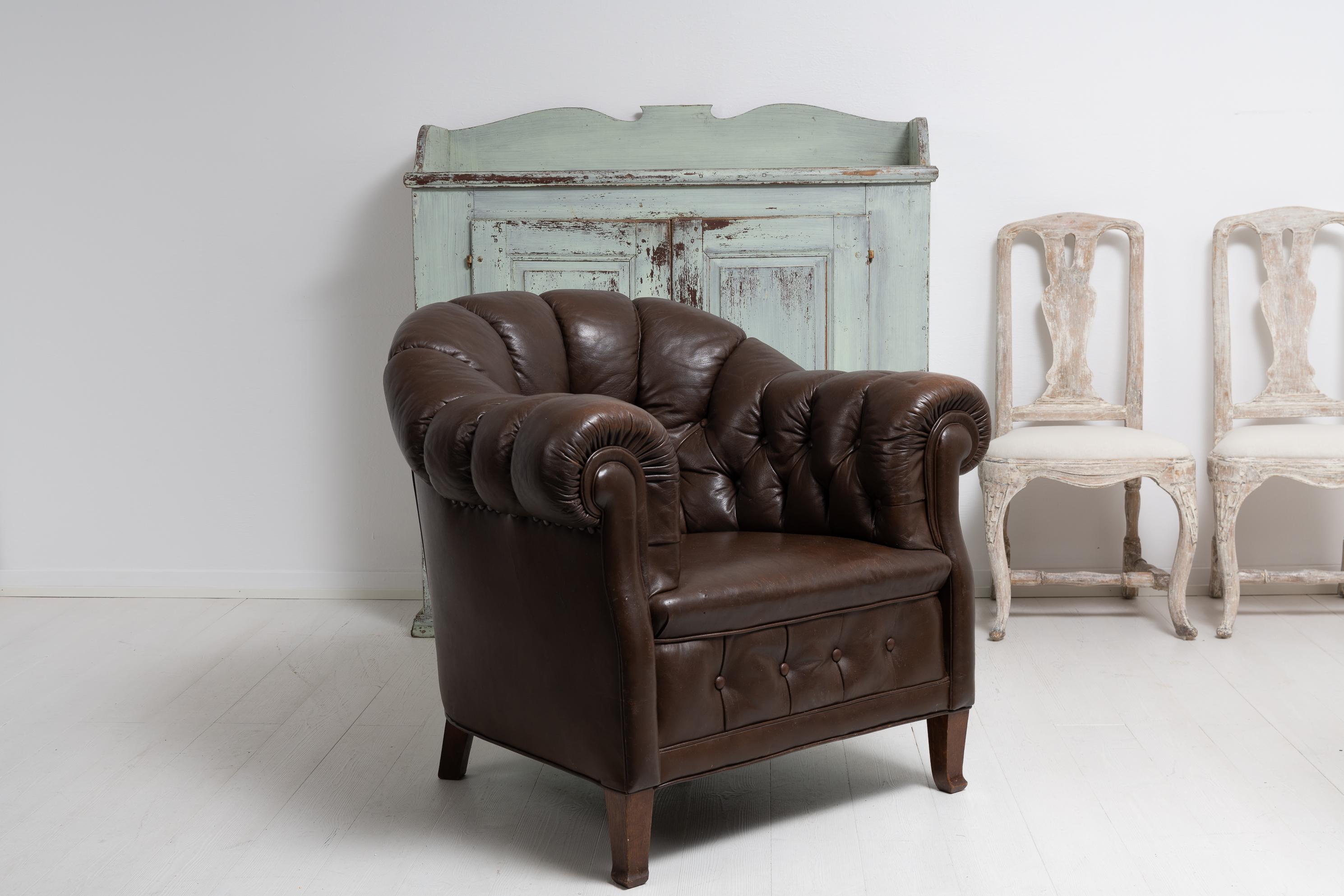 Early 20th century brown leather Chesterfield armchair from Sweden made. The chair is large and generous with the original leather and the patina of time only 100 years of use can create. It is plush and sturdy with an authentic aged look to the