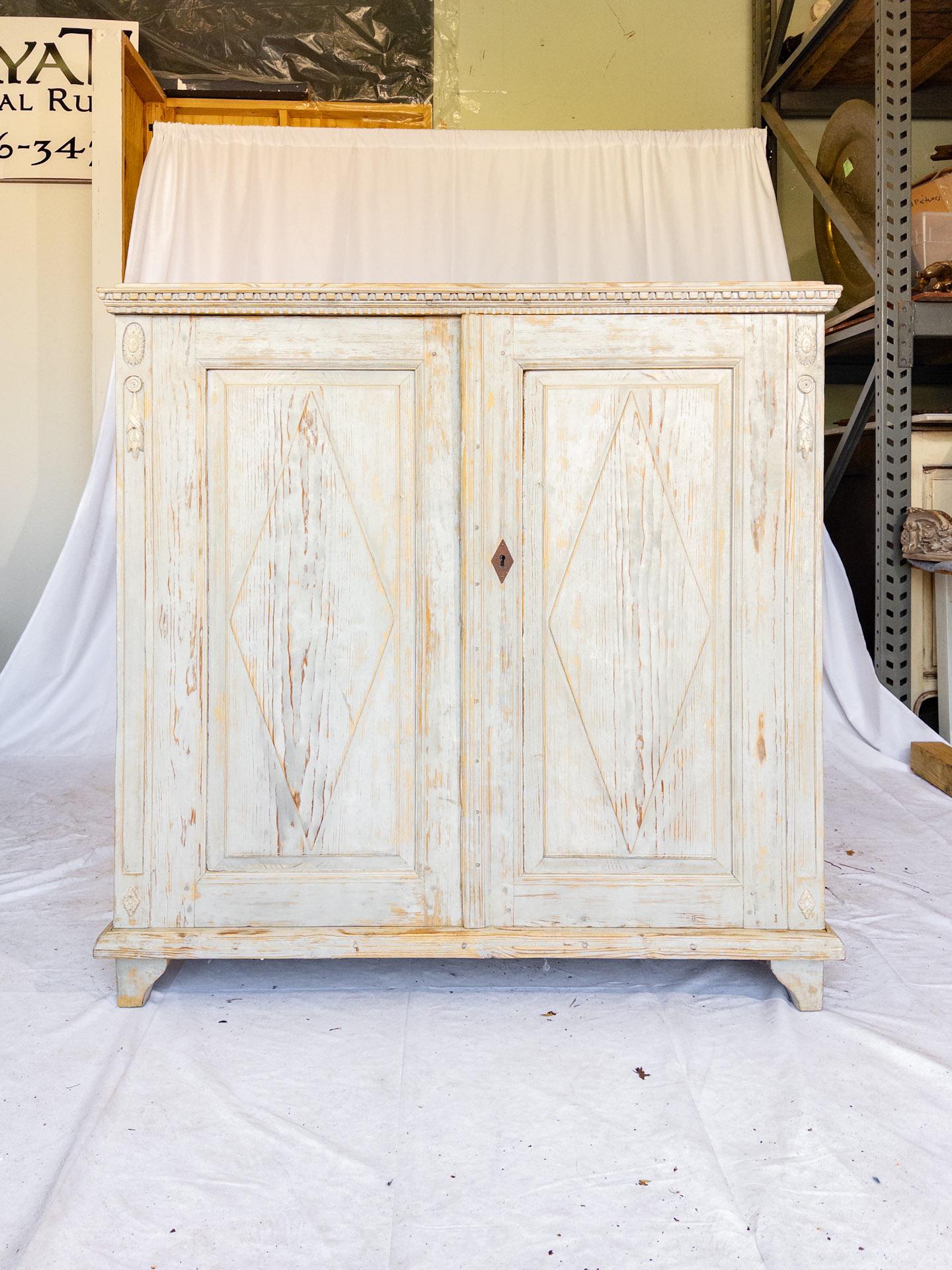The Early 20th Century Swedish Cabinet epitomizes the grace and sophistication of Swedish craftsmanship during this period. Its distinguished features include intricate dental molding detail adorning the crown, adding a touch of refinement and