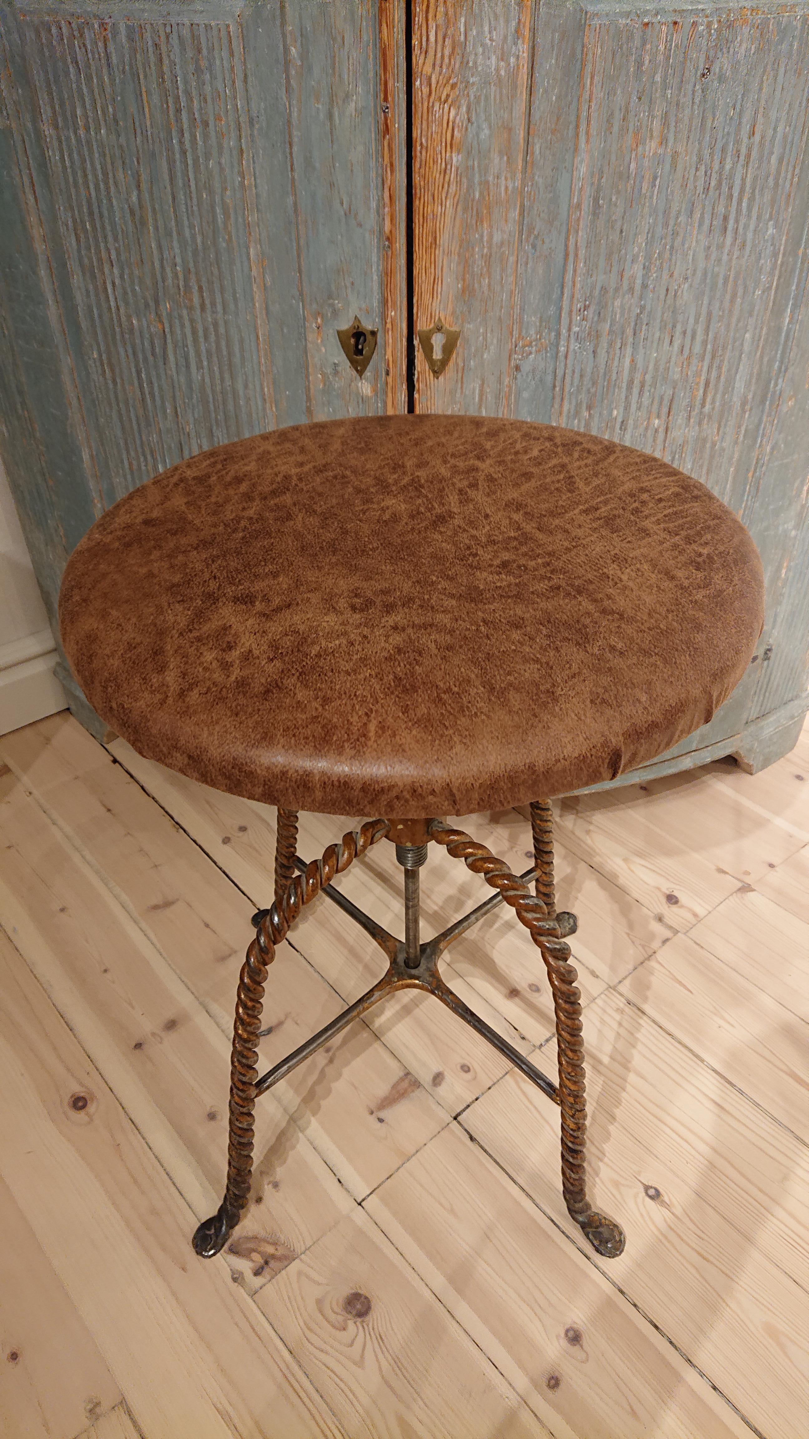 Early 20th century Swedish iron industrial stool.
Solid & useful swivel stool with deliciosly twisted legs in iron.
The stool is raised and lowered.
Measures: Minimum height is 45cm.
Maximum height 60cm.
Upholstered in a leather imitation