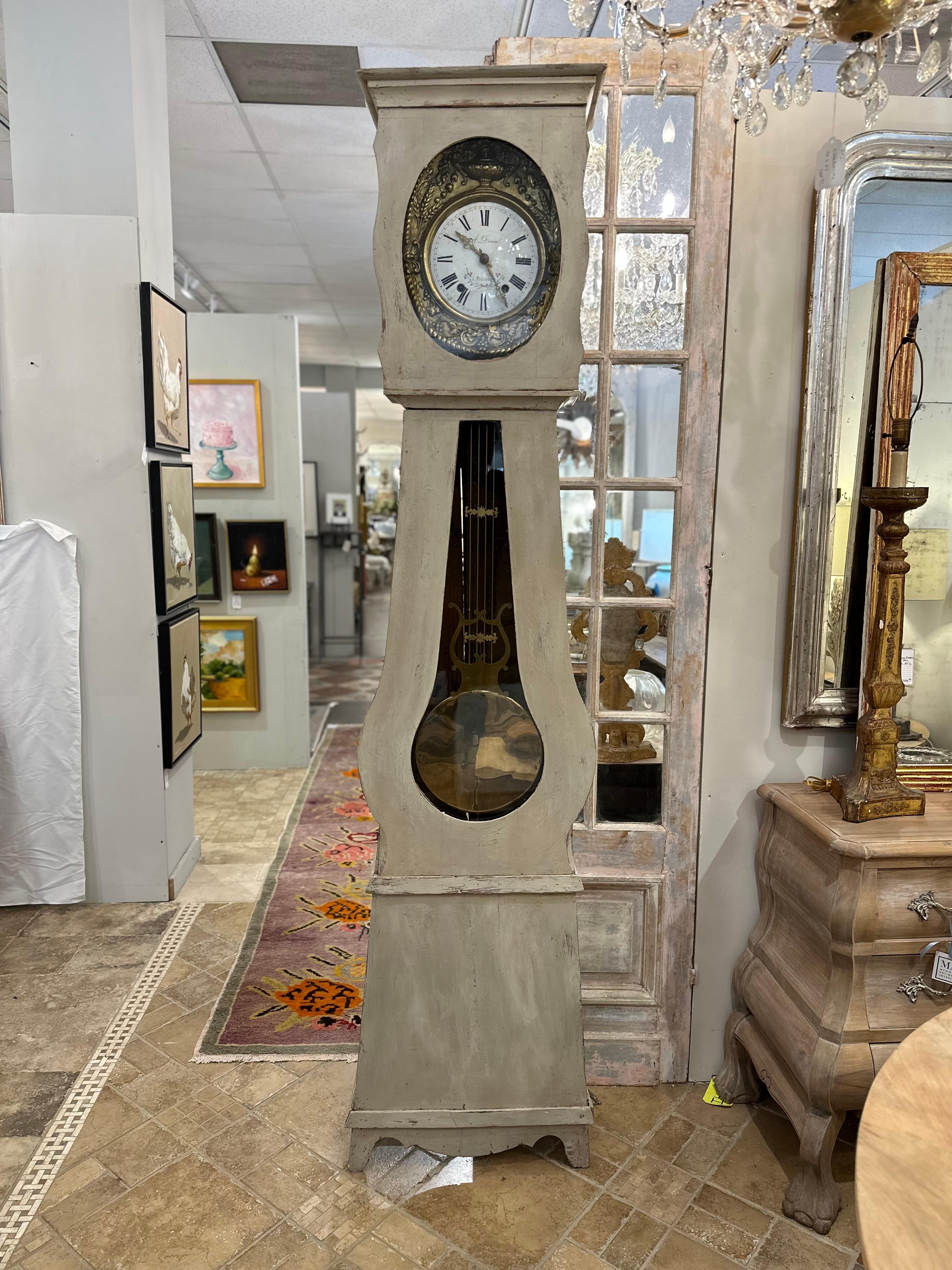 The Early 20th Century Swedish Painted Grandfather Clock stands as a testament to the exquisite craftsmanship and timeless beauty of its era. Gilded and intricately carved around its face, this stately timepiece exudes opulence and grandeur. Its