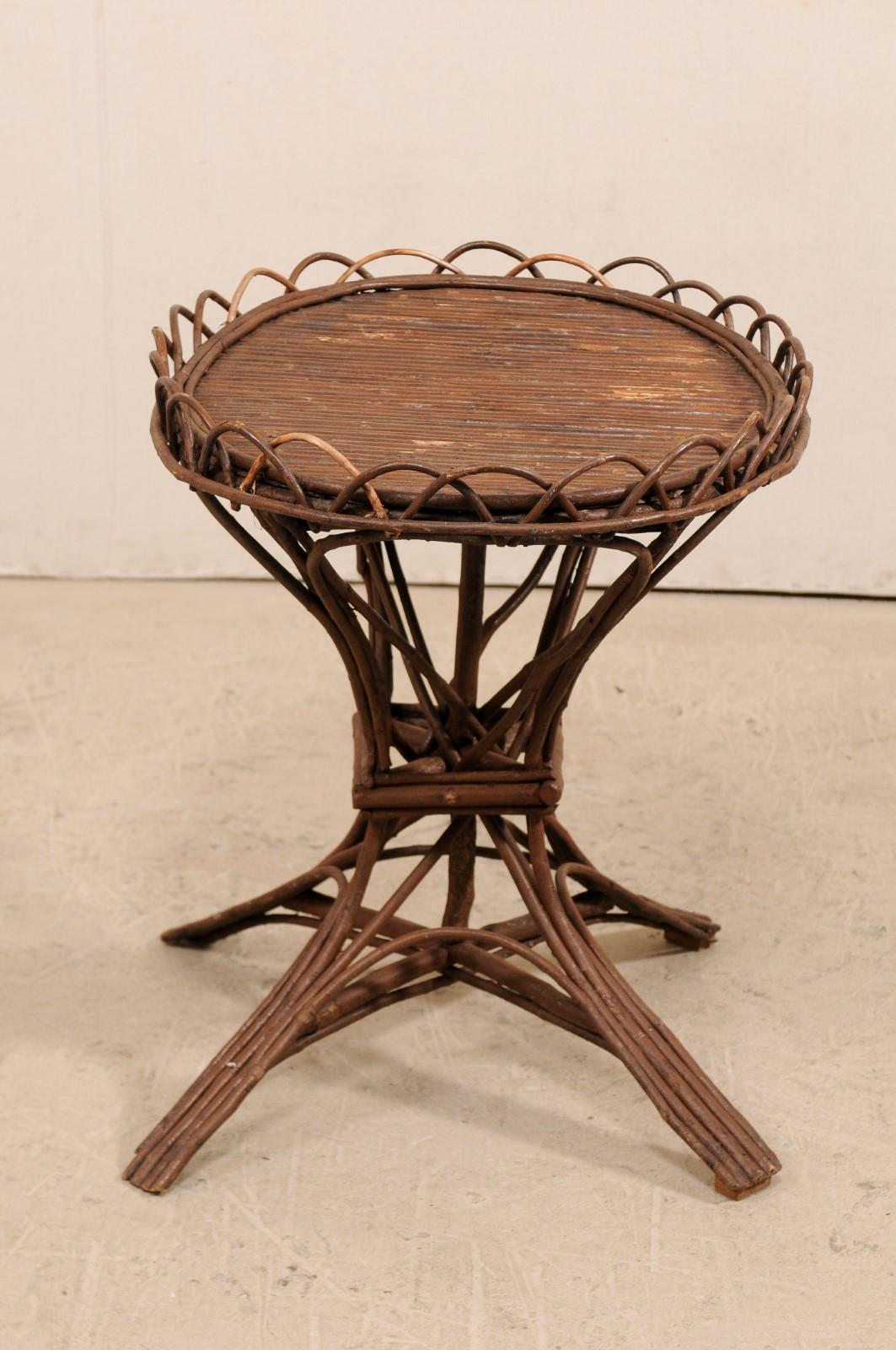 A Swedish early 20th century twig and reed table. This antique table from Sweden features a reeded oval top, with scalloped twig design framing the edges. The top is supported with a base with consists of groupings of various reeds and twigs, which