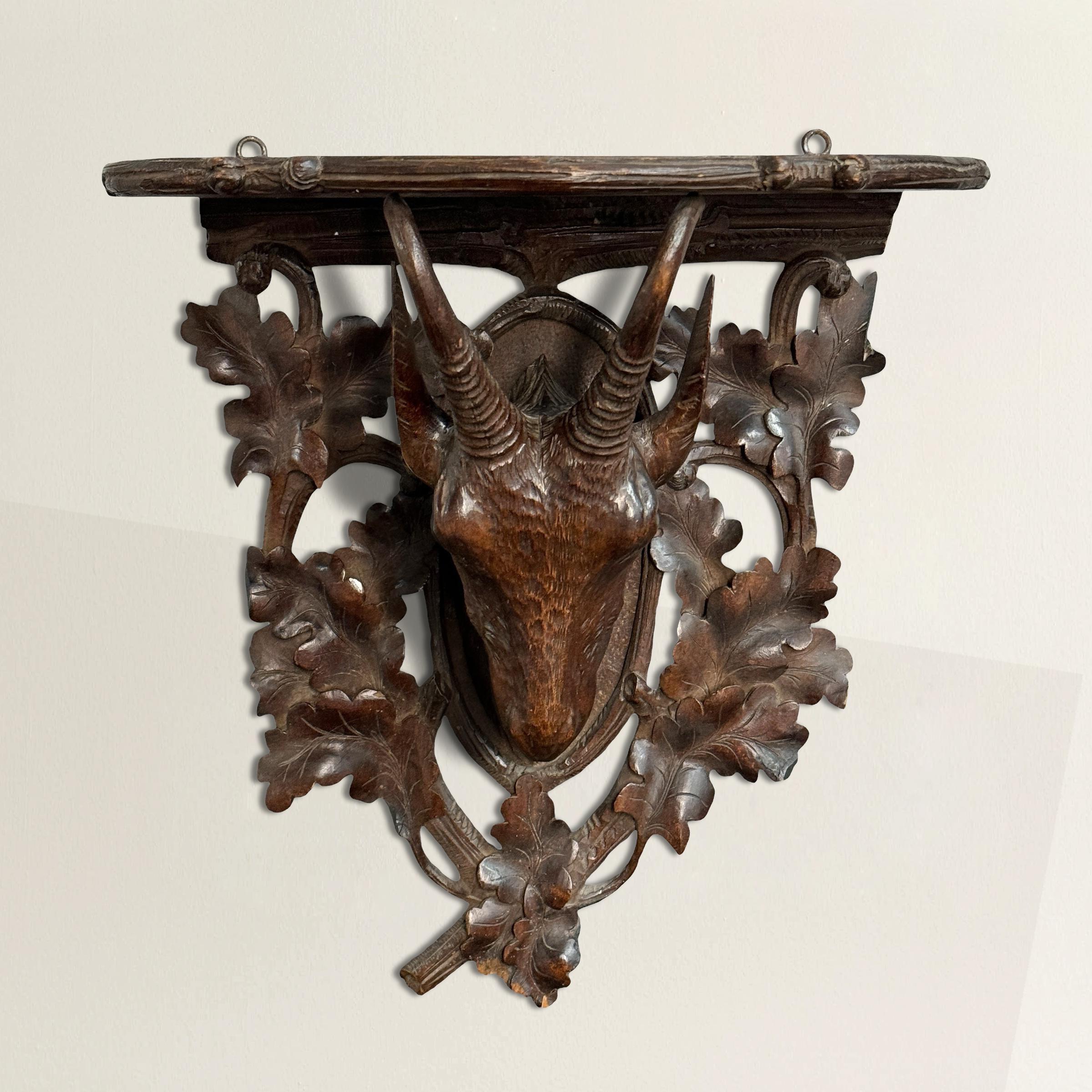 This early 20th-century Swiss Black Forest hand-carved wood wall bracket is a stunning representation of the region’s renowned craftsmanship. The bracket features a beautifully detailed chamois head, its graceful horns and lifelike expression