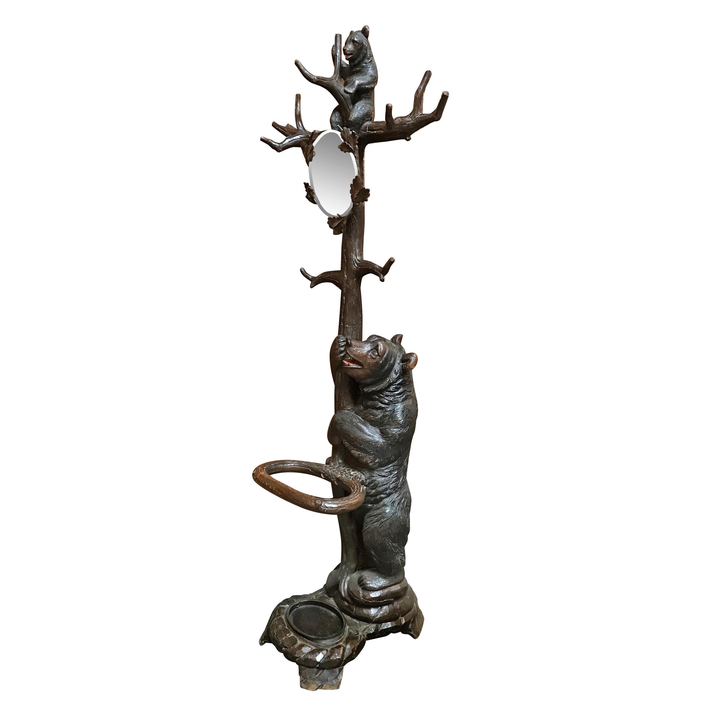 A whimsical early 20th century Swiss Black Forest carved wood hall tree attributed to Seilar-Brawant of Brienz, Switzerland. The bears are wonderfully expressive, with glass eyes, and painted mouths, with the cub climbing up a tree with ten branches
