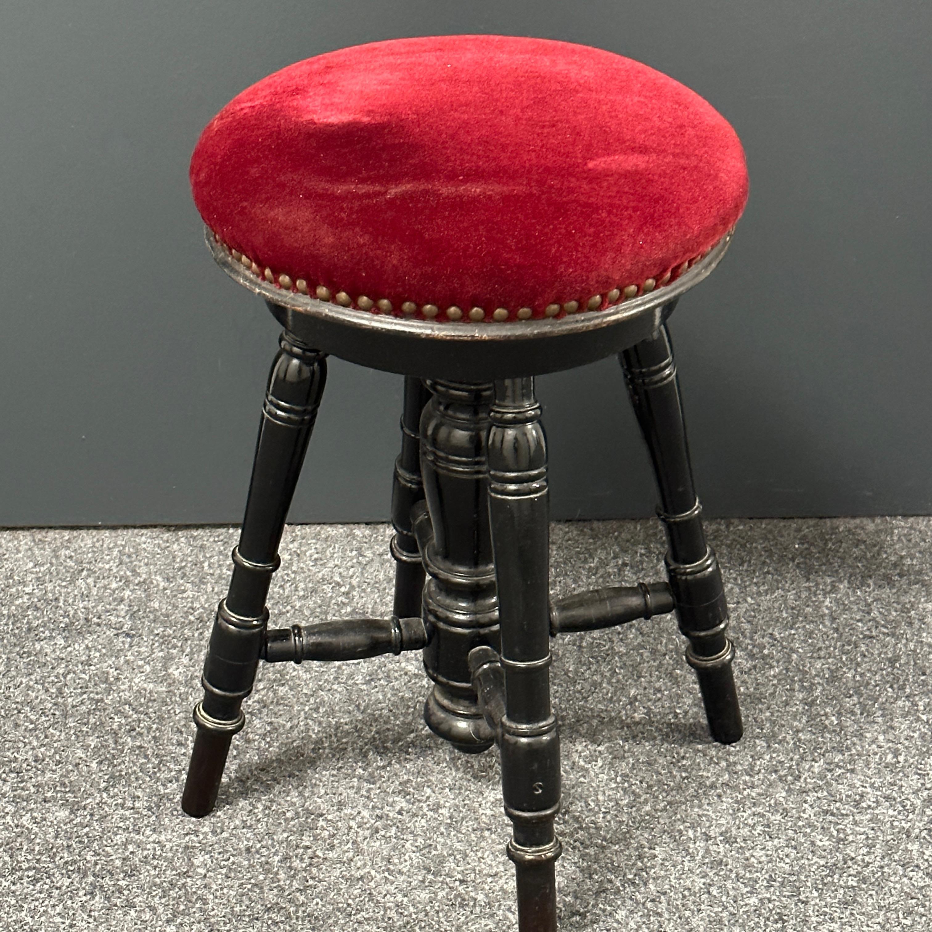 This charming early 20th century four-legged upholstered swivel 'Bobbin' stool in ebonised wood with a red velvet seat is in very good condition.
It is height adjustable. The highest height is approx. 24