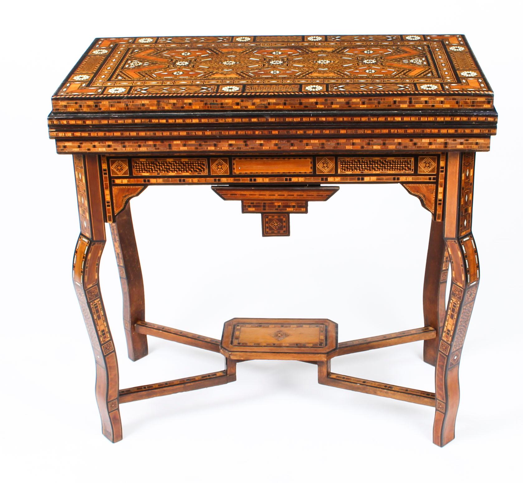 This profusely inlaid Syrian Damascus games table dates from circa 1910, and has multiple geometric and asymmetric inlays of various woods and mother of pearl.

The hinged lid opens to reveal a similarly inlaid interior and a removable reversible