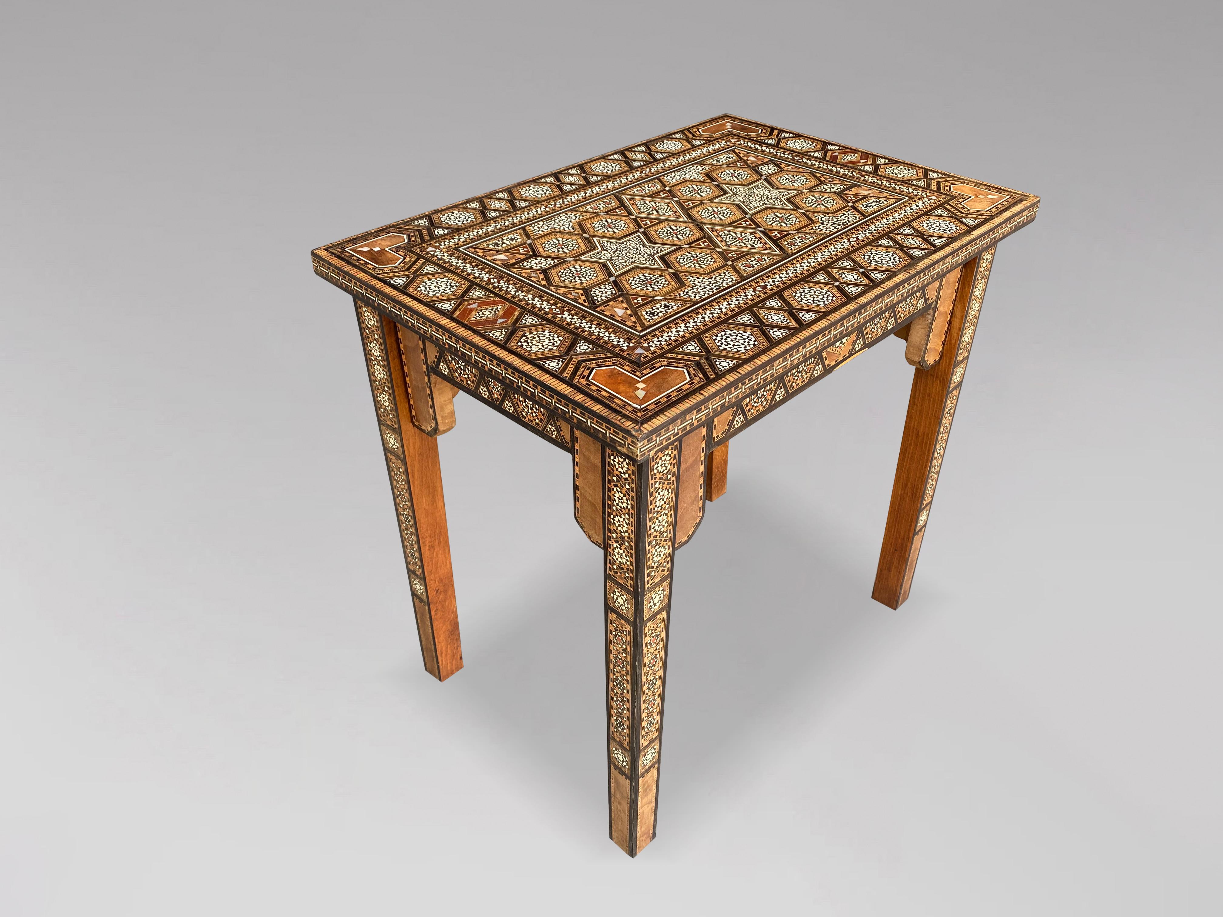 A fine early 20th century inlaid Syrian occasional table of rectangular form with an intricate geometric pattern, inlaid with mosaic bone, ebony, mother of pearl and other woods marquetry work throughout, having a shaped apron and raised upon square