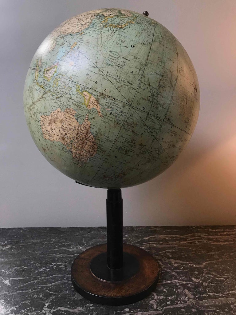 Early 20th century tall globe on black wood stand from Italy. 
