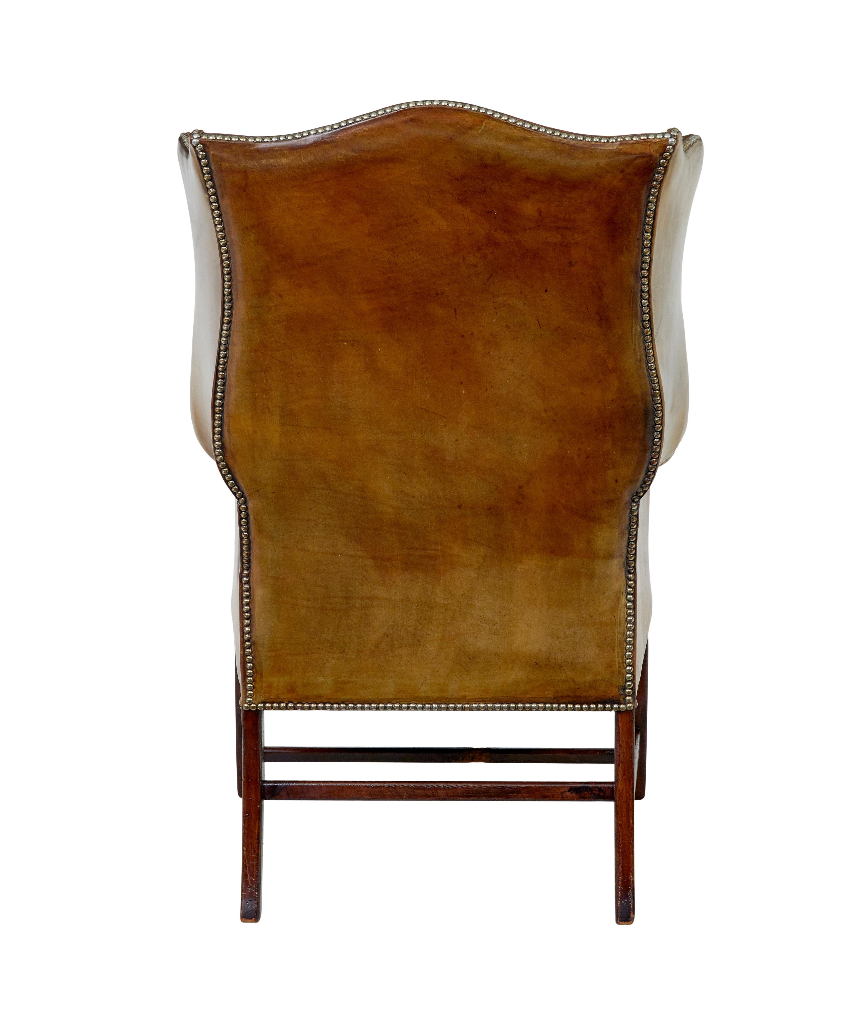 Sillón con respaldo de ala de cuero curtido de principios del siglo XX Tallado a mano en venta