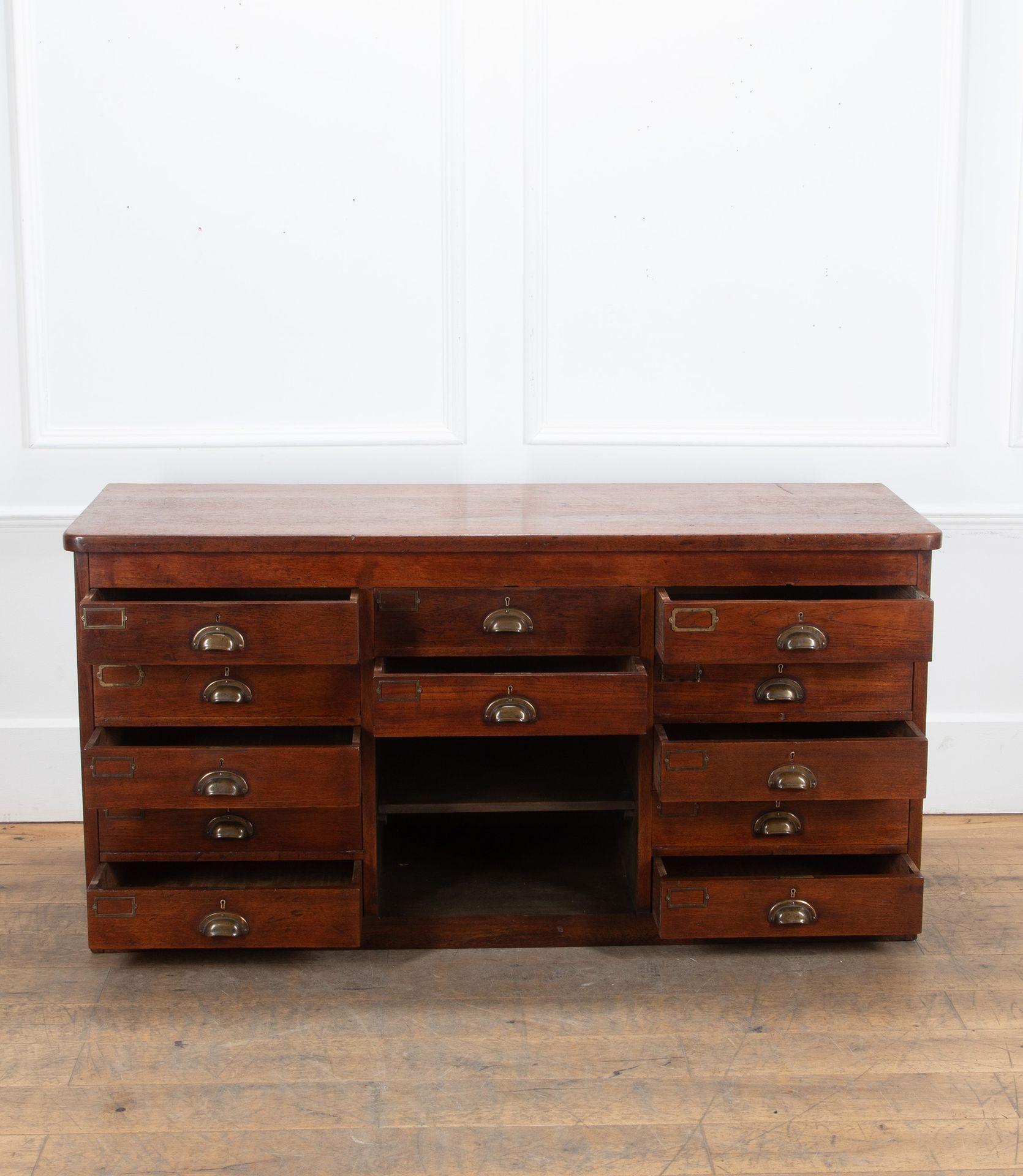 Banca di cassetti in teak inglese dei primi del Novecento.
Con dodici cassetti e due ripiani, conserva le maniglie a tazza in ottone originali e una bella patina calda.
Circa 1900.