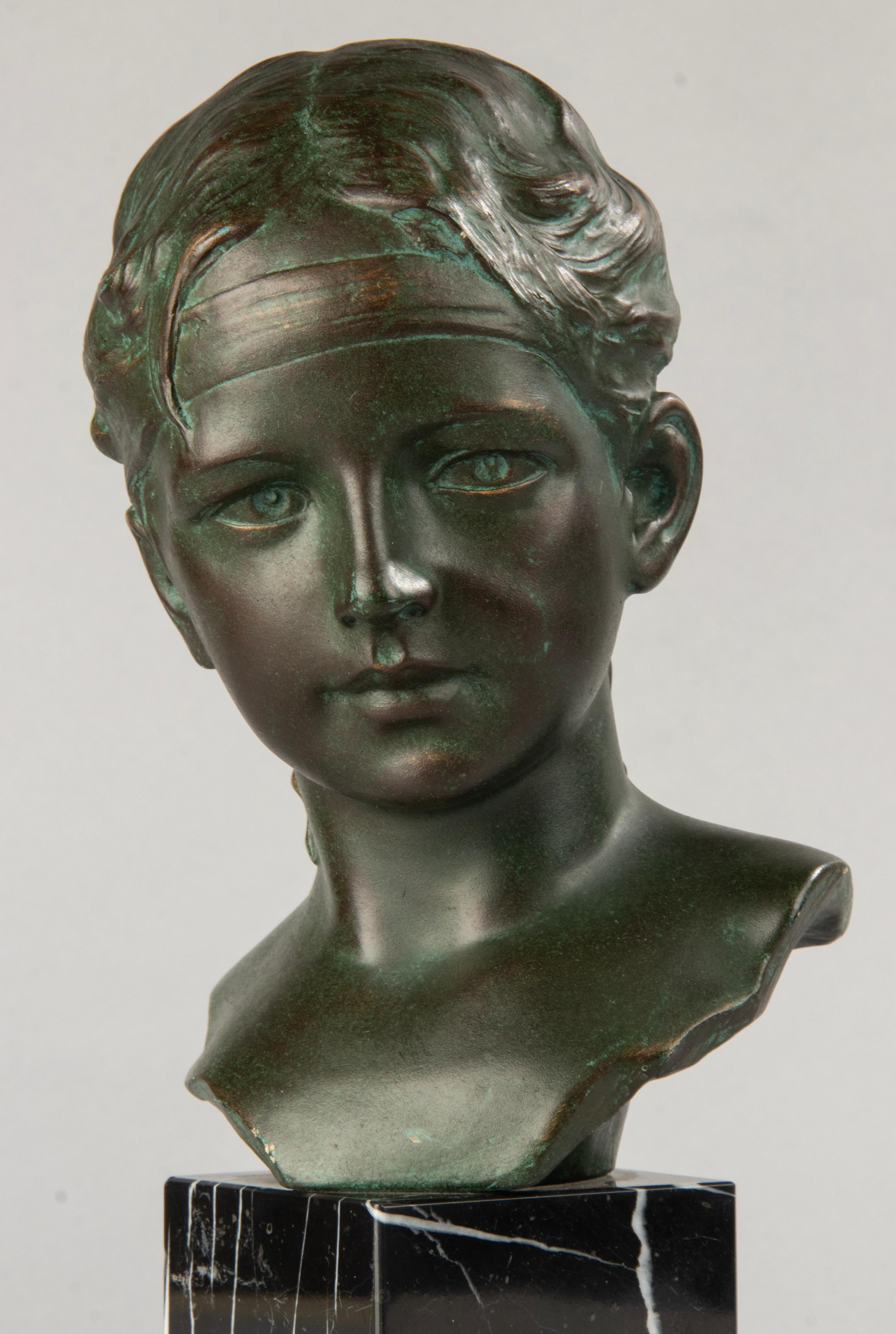 An Art Deco sculpture of a young girl, made of plaster. With a beautiful green patina. On a black Belgian marble pedestal. In a good and original condition. Made in Belgium, circa 1920-1930 by the Italian sculptor Giuseppe Carli.

The Carli family
