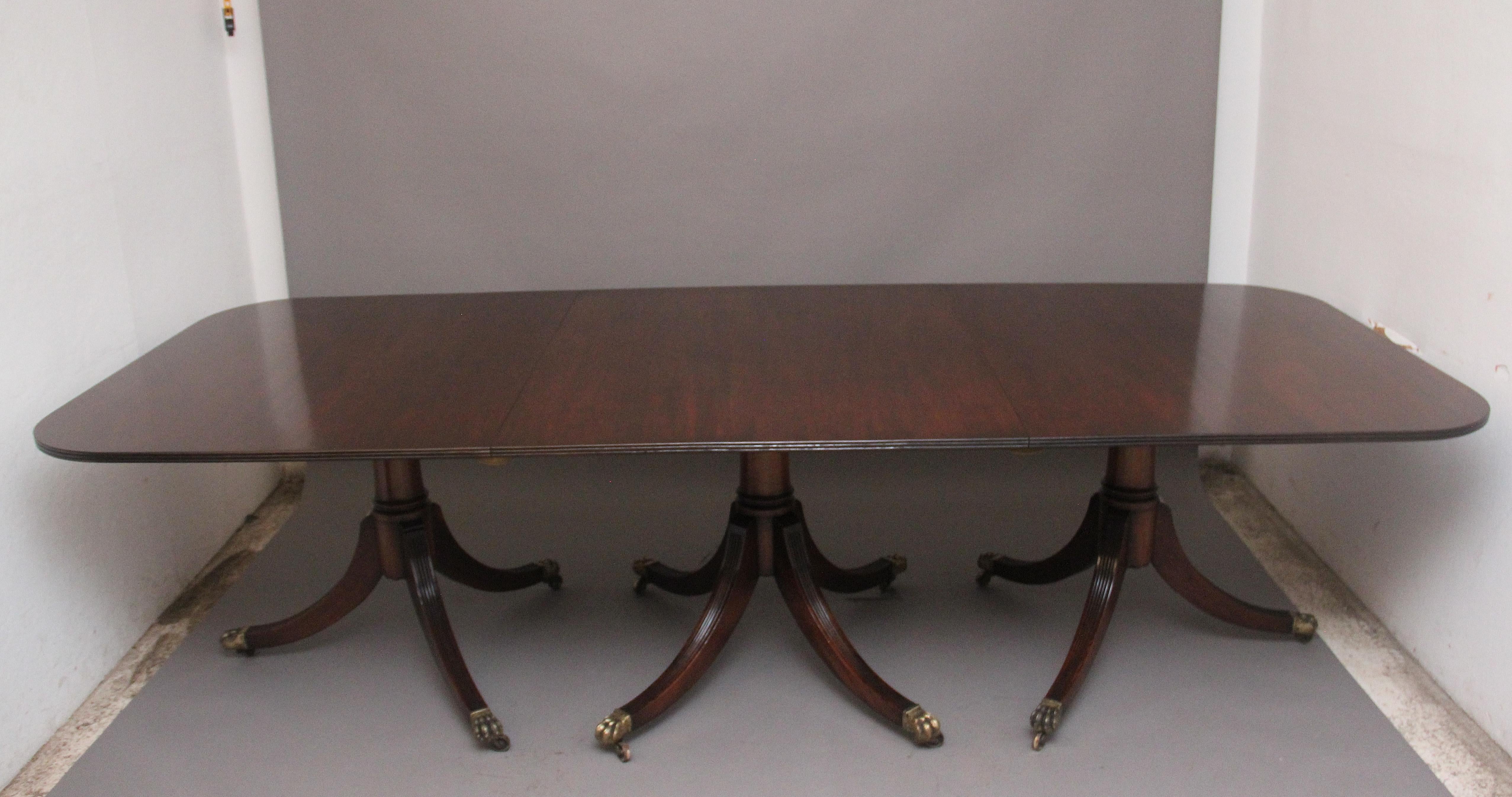 A large and impressive early 20th Century three pedestal mahogany dining table of exceptional quality,  the rounded rectangular top incorporating two extra leaves, wonderful figured tops supported on decorative turned columns with splay legs
