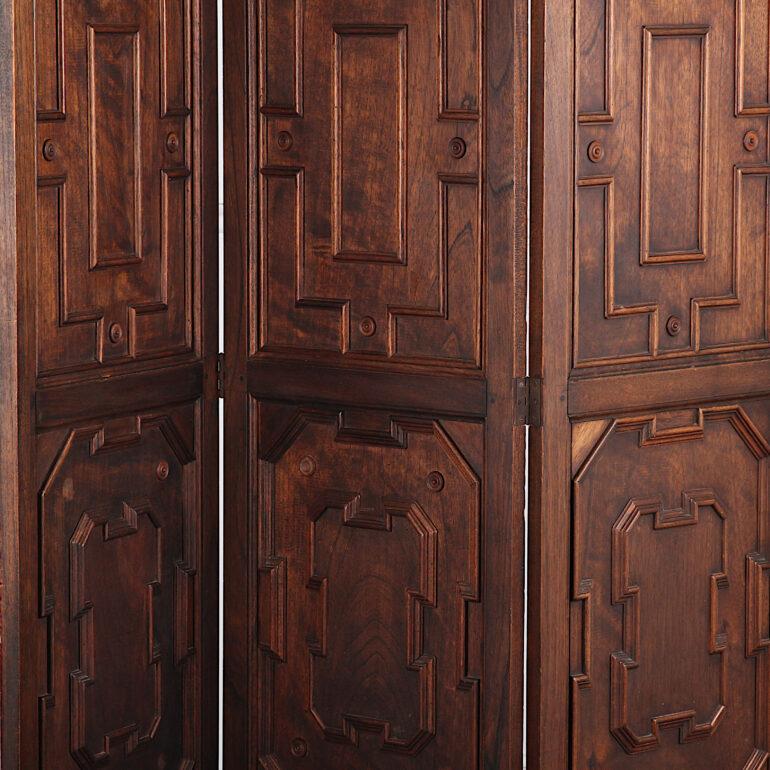 An English solid chestnut three panel screen or room divider, each section with molded paneled details and turned spindles at the top. 

  