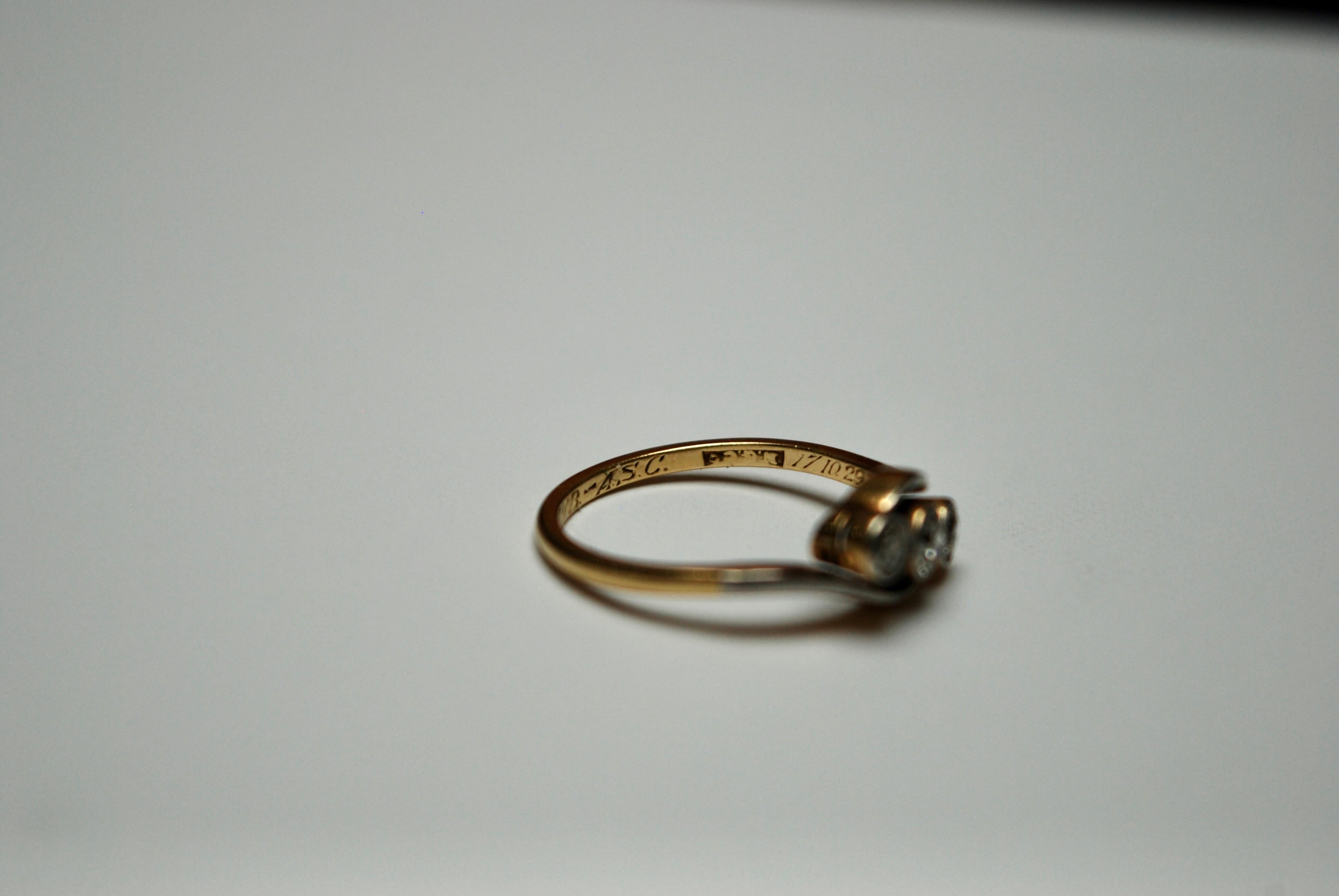 An early 20th century three stone old European-cut diamond ring, millegrain set with a swirl design encompassing the stones. Hallmarked 18k gold. 

Date: 1929
weight: 3.1g
Size: US 7
Hallmarks: 18k gold
