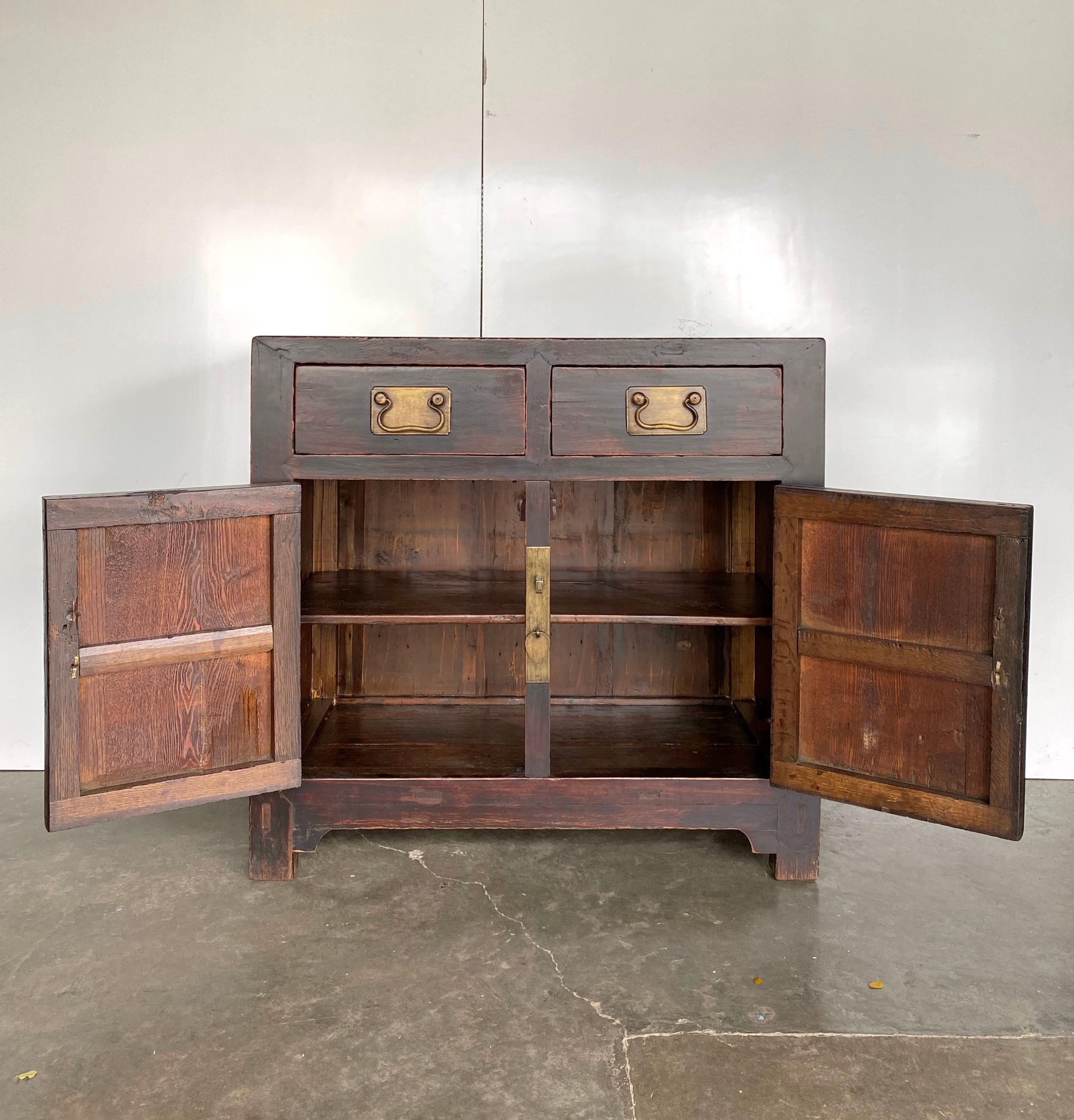 A very handsome square-cornered cabinet from Tianjin, approx. 100 years old. Made of Elm and Pine woods, we had left the beautiful original reddish brown colour on this piece original, finishing it with a semi-matte clear lacquer. The solid brass