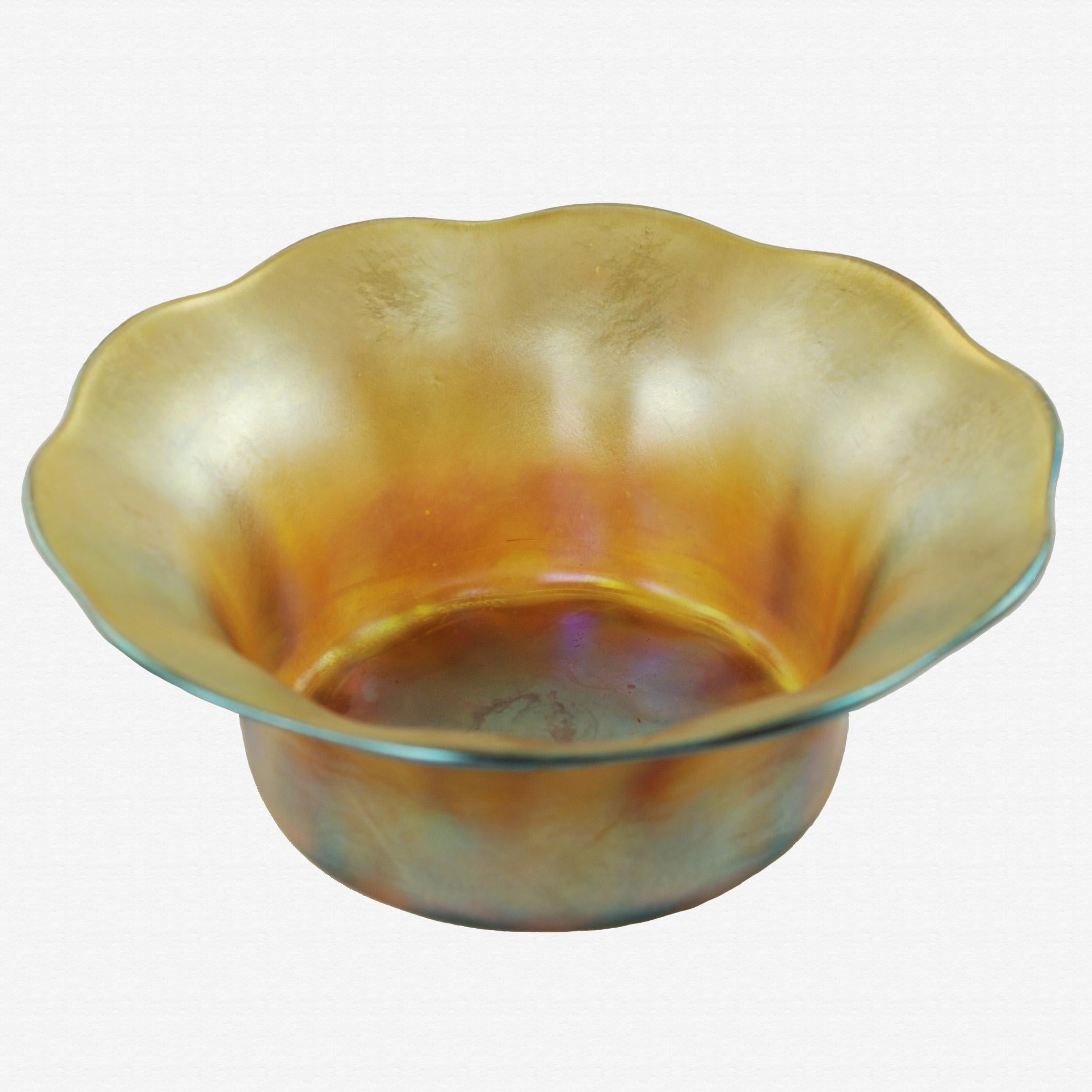 This Tiffany iridescent gold Favrile glass five-piece set includes a fruit bowl and four individual serving bowls. The matched set has cylindrical bodies with flared rims having scalloped edges. The pieces are all signed and numbered, with the large