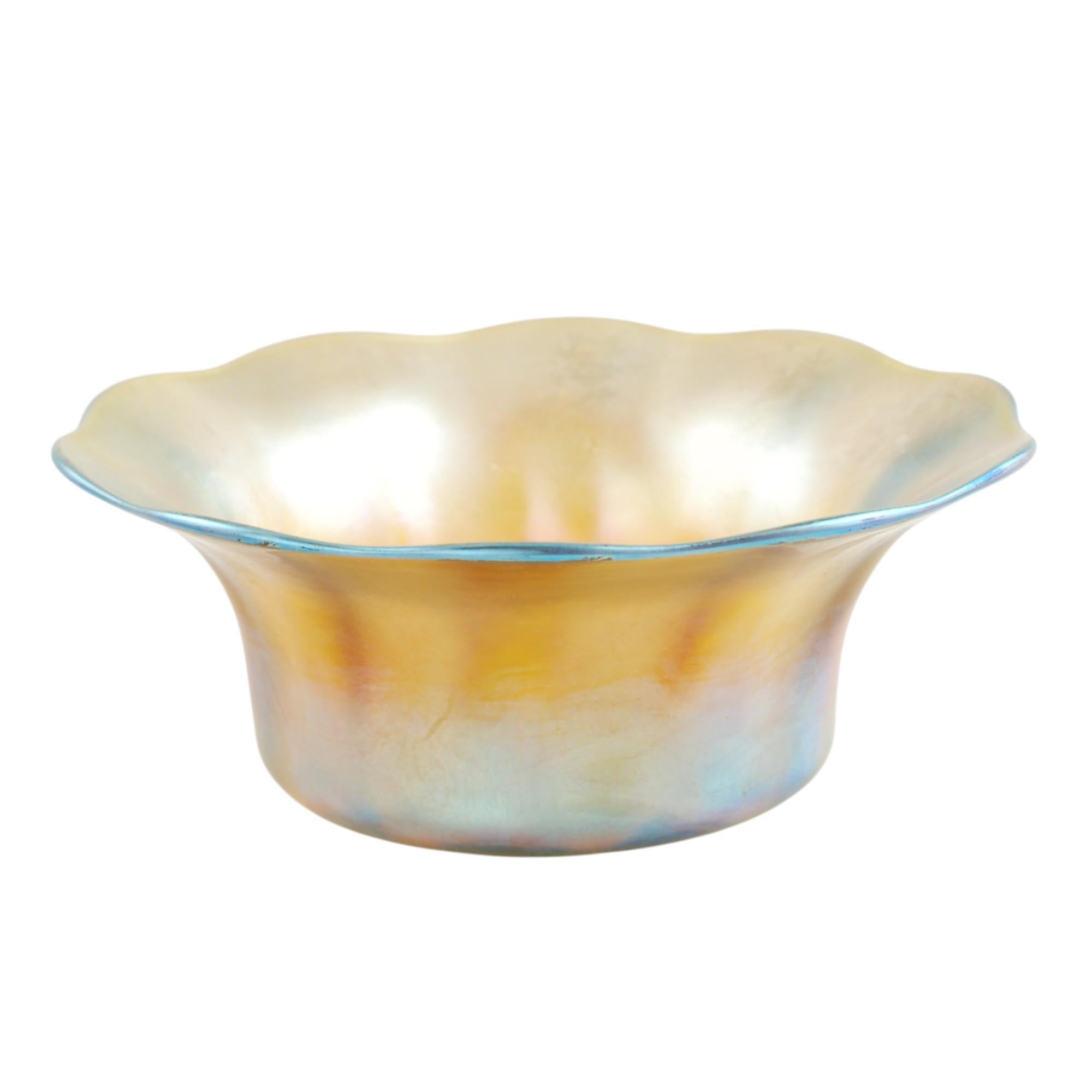Cet ensemble de cinq pièces en verre Favrile or irisé de Tiffany comprend un bol à fruits et quatre bols de service individuels. L'ensemble assorti a des corps cylindriques avec des bords évasés ayant des bords festonnés. Les pièces sont toutes