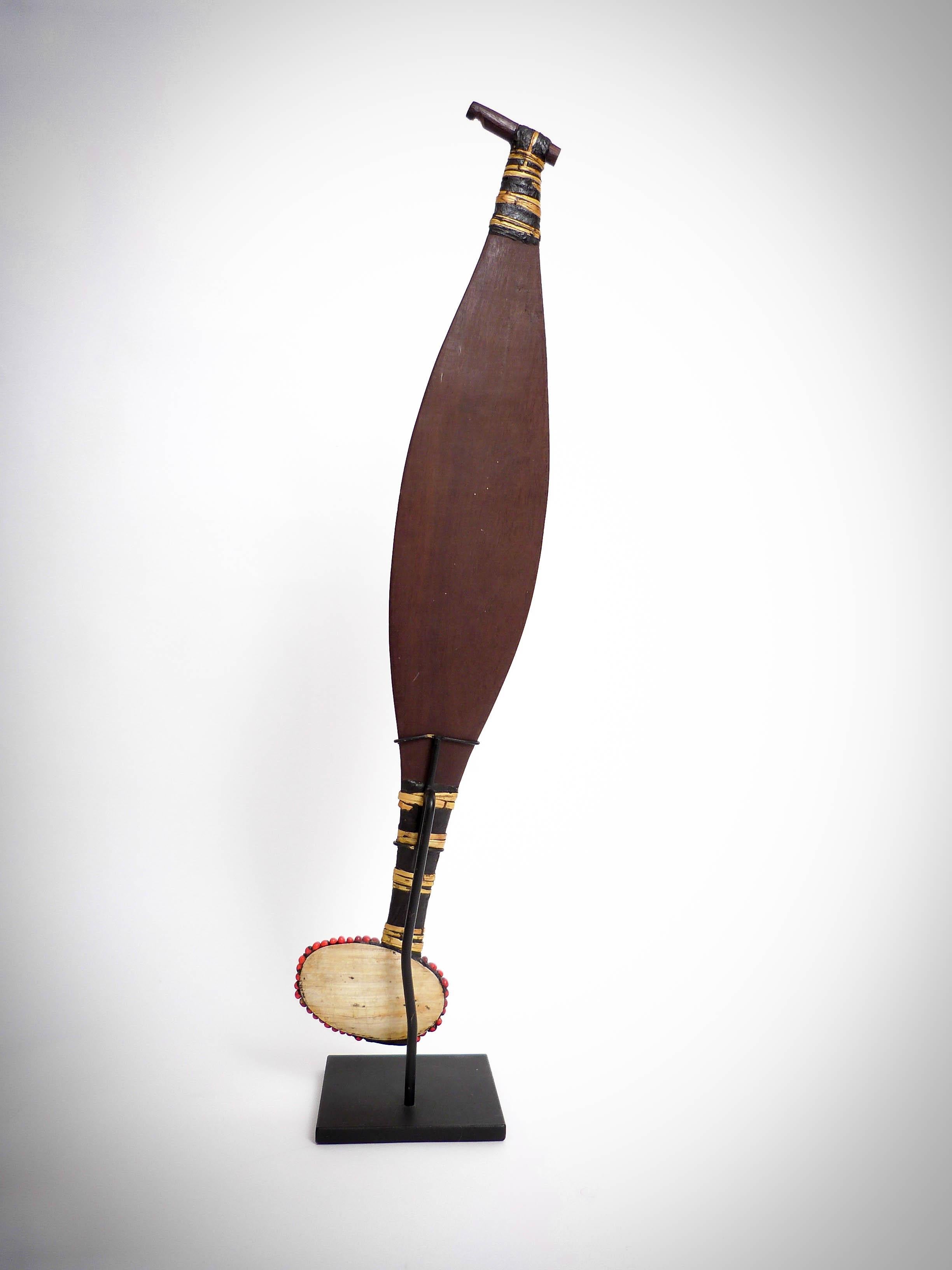Aboriginal spearthrower carved and incised wood, abrus seeds, cane, shell and gum resin. 62.5cms long, 10.5cms wide. Aboriginal tribes, north Australia, Queensland.