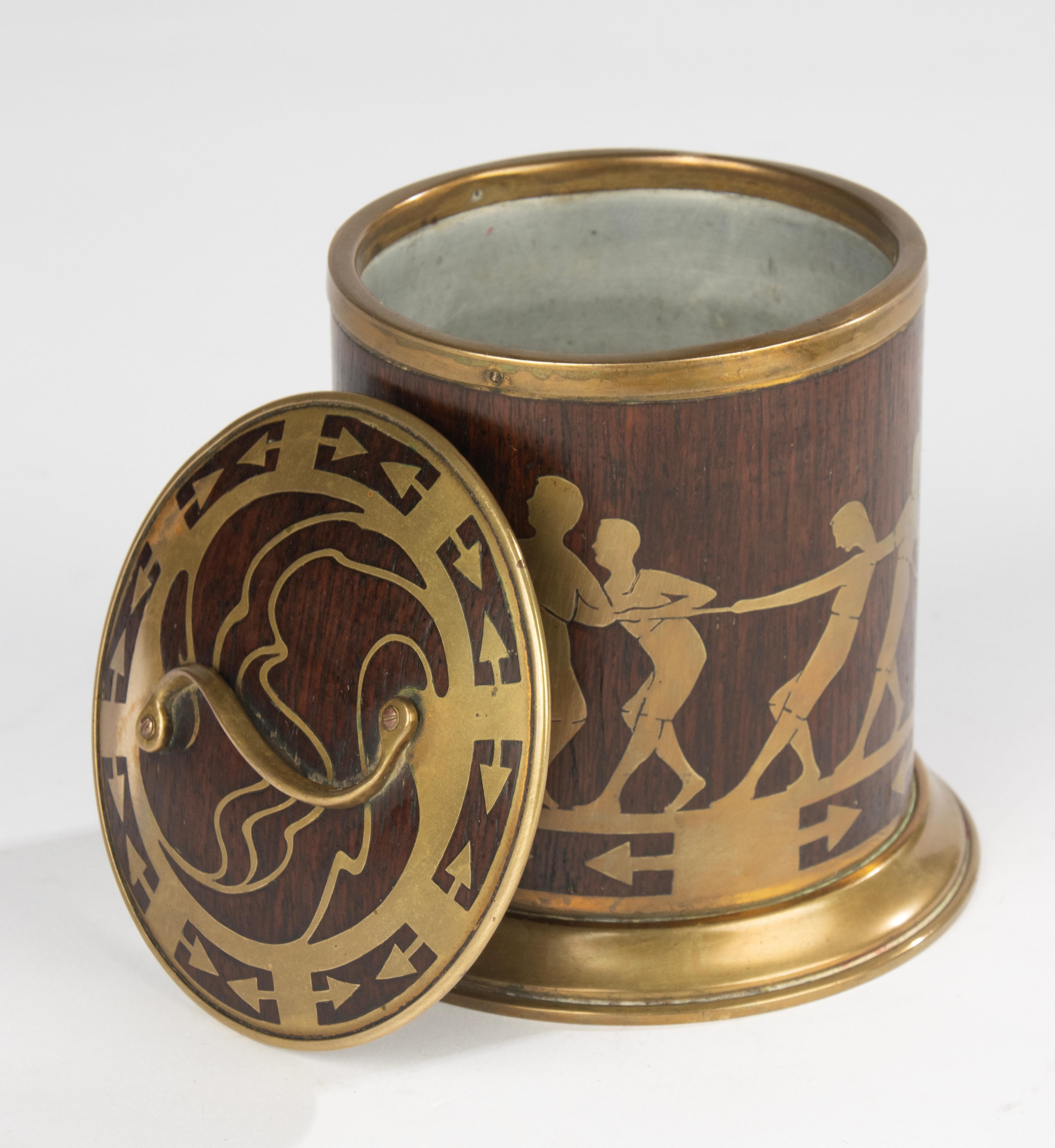 An elegant early 20th century tobacco jar attributed to Erhard & Söhne, the renowned German makers celebrated for their refined Art Nouveau brasswork. The cylindrical body is made of dark-stained wood and richly decorated with brass inlay depicting