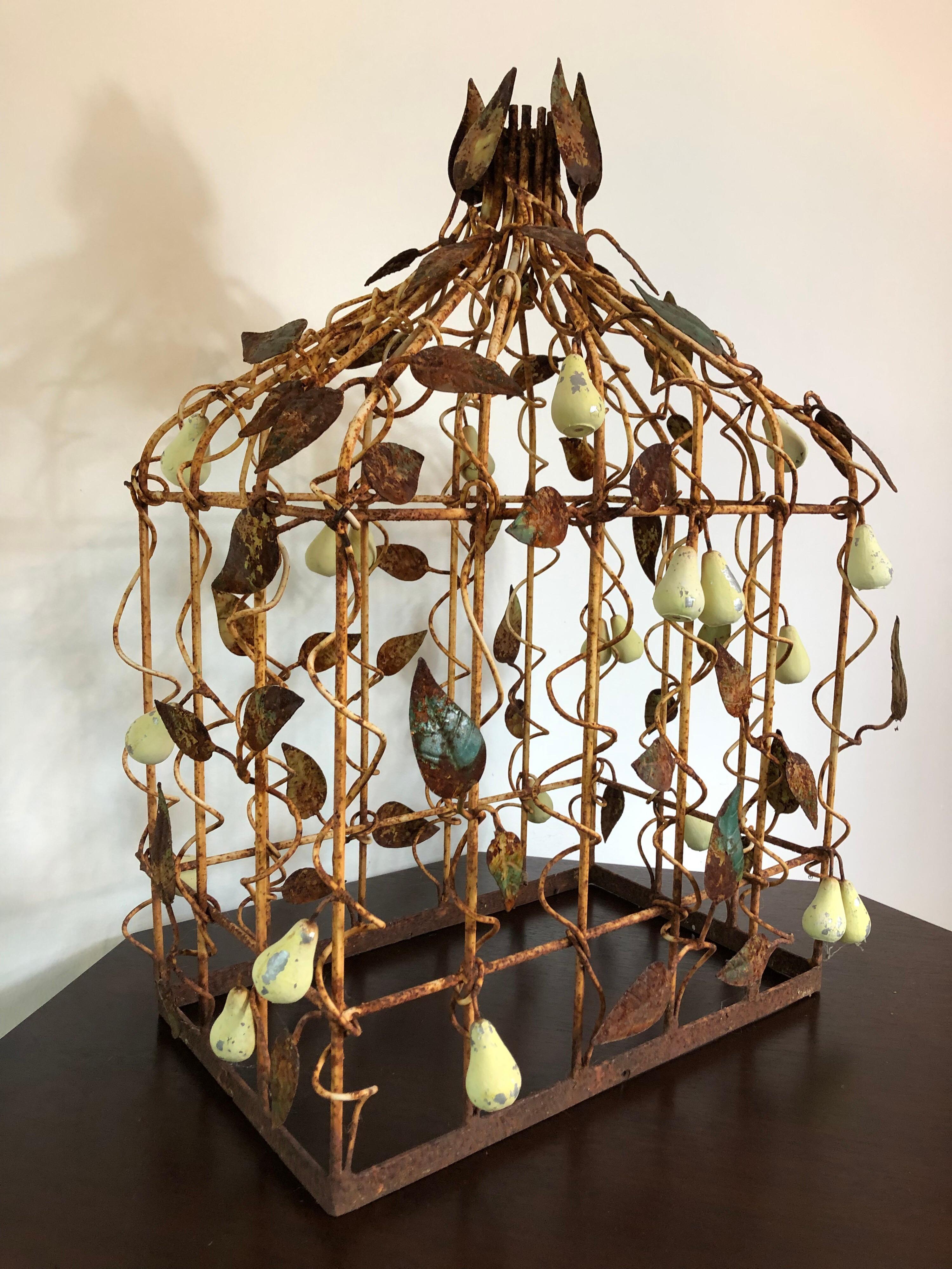 Une cage à oiseaux en métal du début du 20e siècle, décorée de poires et de feuilles en tole. Belle patine du métal et superbe pièce décorative d'intérieur ou d'extérieur.