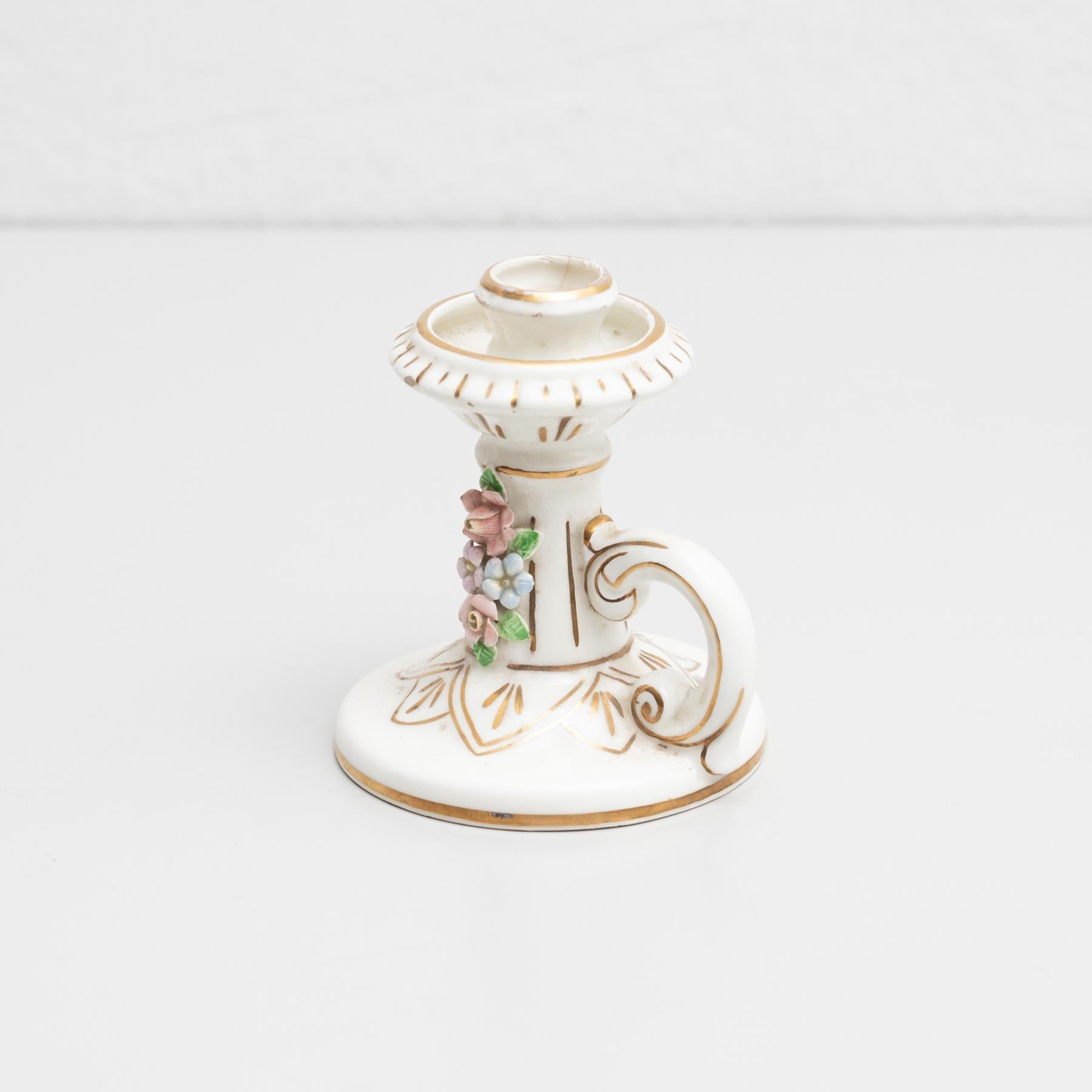 Traditional ceramic hand-painted candle holder decorated with a floral design.    Made by unknown manufacturer in Spain, circa 1960.    In original condition, with minor wear consistent with age and use, preserving a beautiful patina.    Materials: 