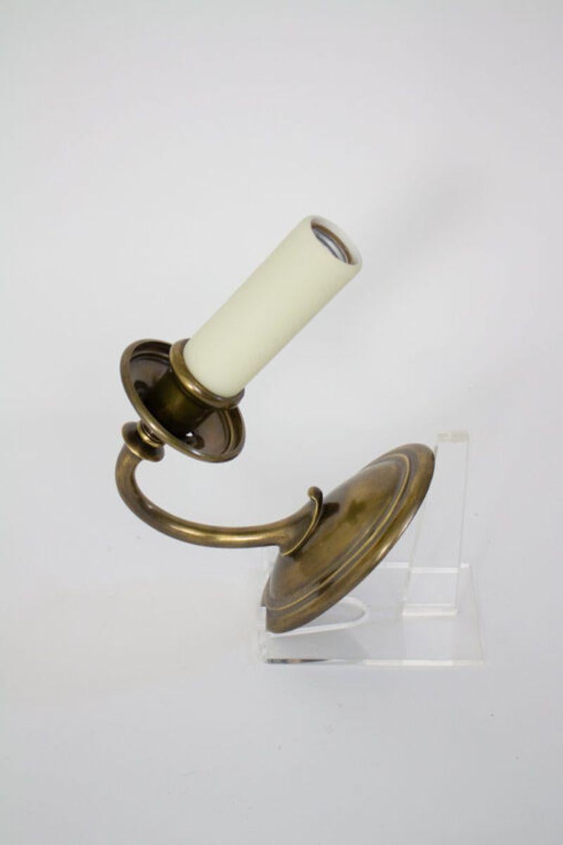 Single arm elegant sconce. Finely cast brass.  Oval backplate with a upward curved arm and a single socket.  A single sconce.  

Material: Brass
Period Made: Early 20th Century
Dimension: 4 × 7 × 9 in
Condition Details: Completely Restored and