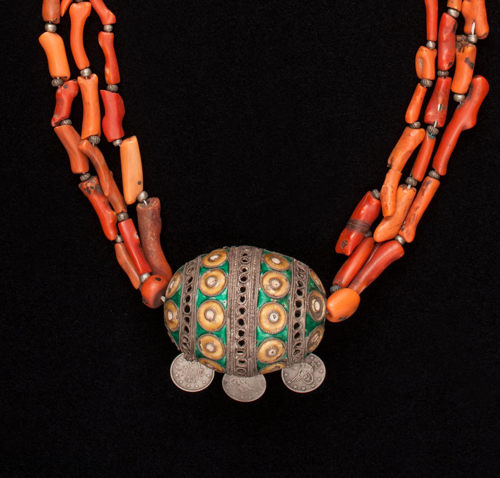 Early 20th century tribal coral pendant necklace, Anti Atlas Mountains, Morocco.

A three-strand antique coral necklace and enameled silver pendant with three hanging silver coins. It measures 28